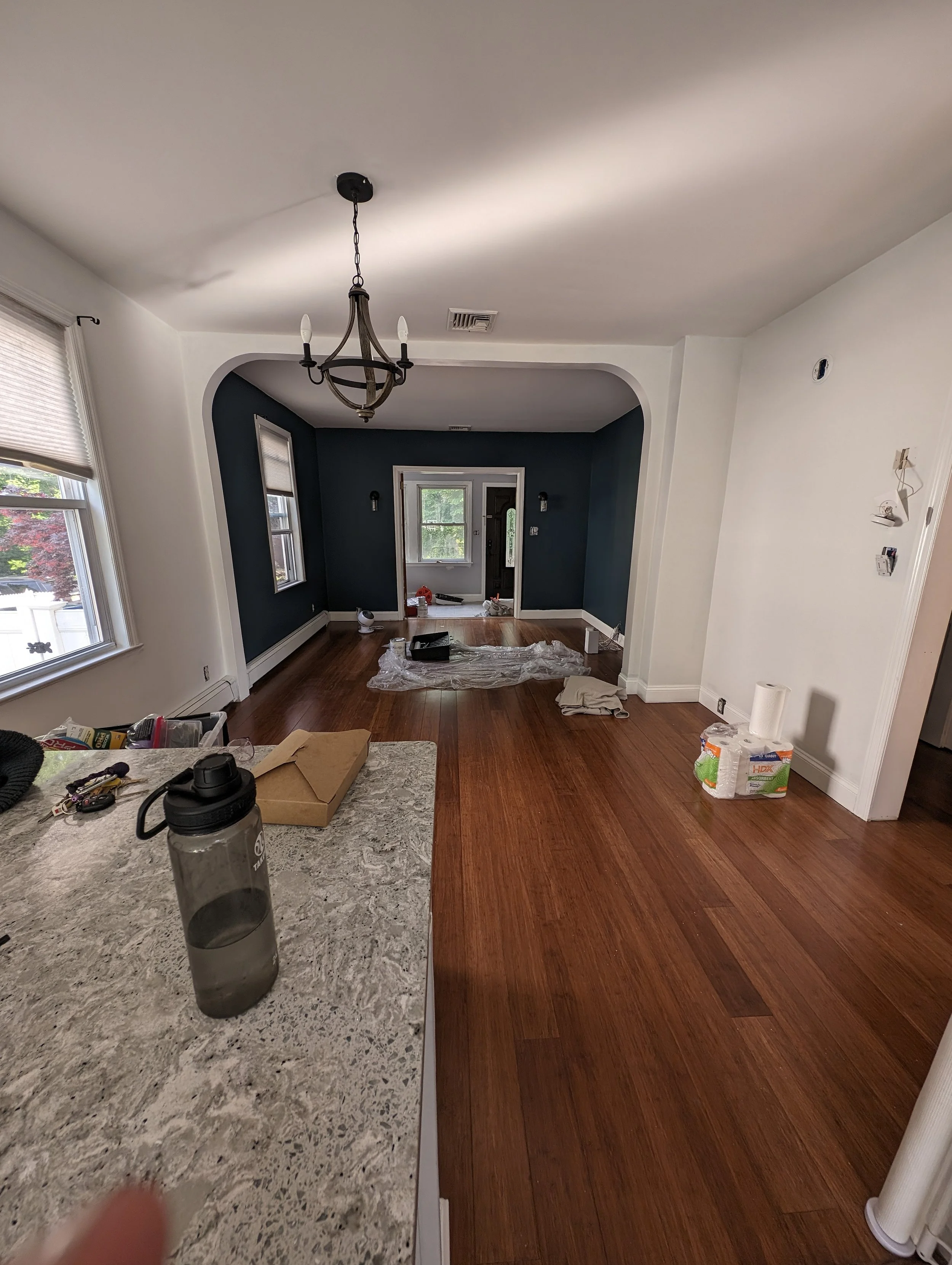 Painted this open concept shared living and dining area two different colors. A bright white in the dining area and a deep moody blue in the living area