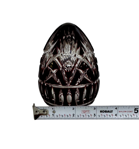 Vintage Hungarian ruby crystal egg beside a tape measure showing a width of approximately three inches