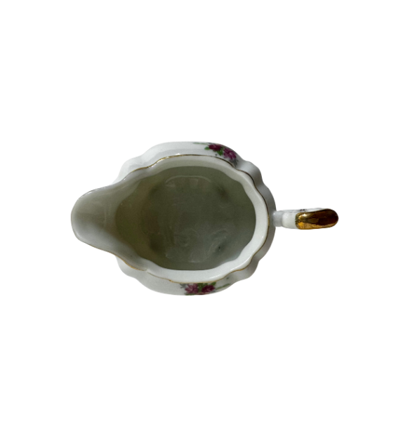 Top view inside the vintage porcelain creamer showing its scalloped opening, pouring spout, and gold-trimmed handle