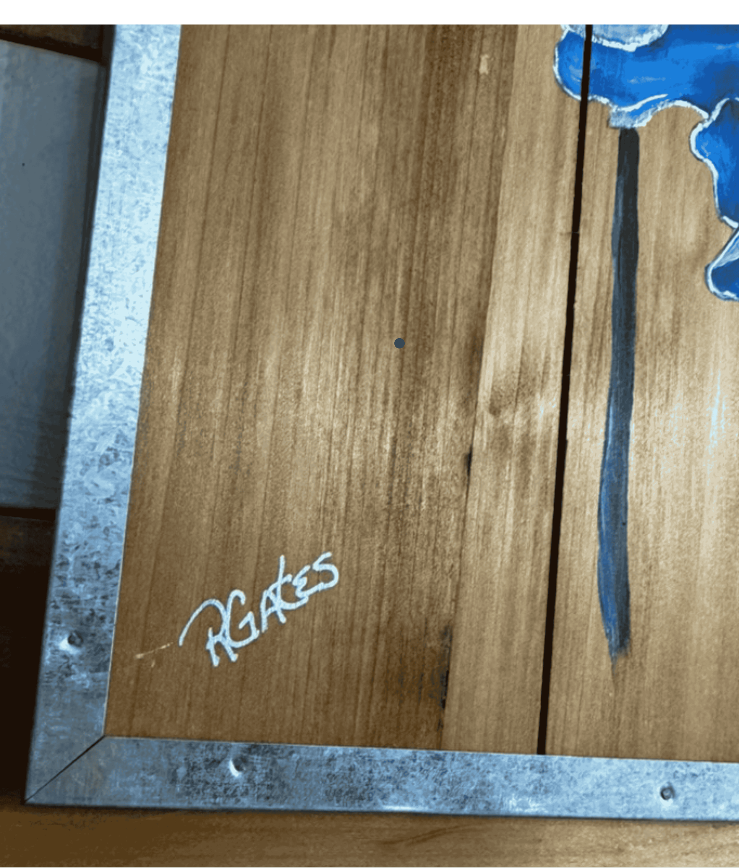 Artist signature detail on original blue iris floral painting by R. Gates on rustic wood panel.