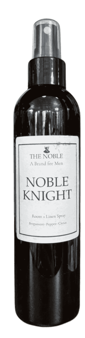 Close-up detail of The Noble “Noble Knight” room and linen spray label showing the brand mark and fragrance notes bergamot, pepper, and citrus.