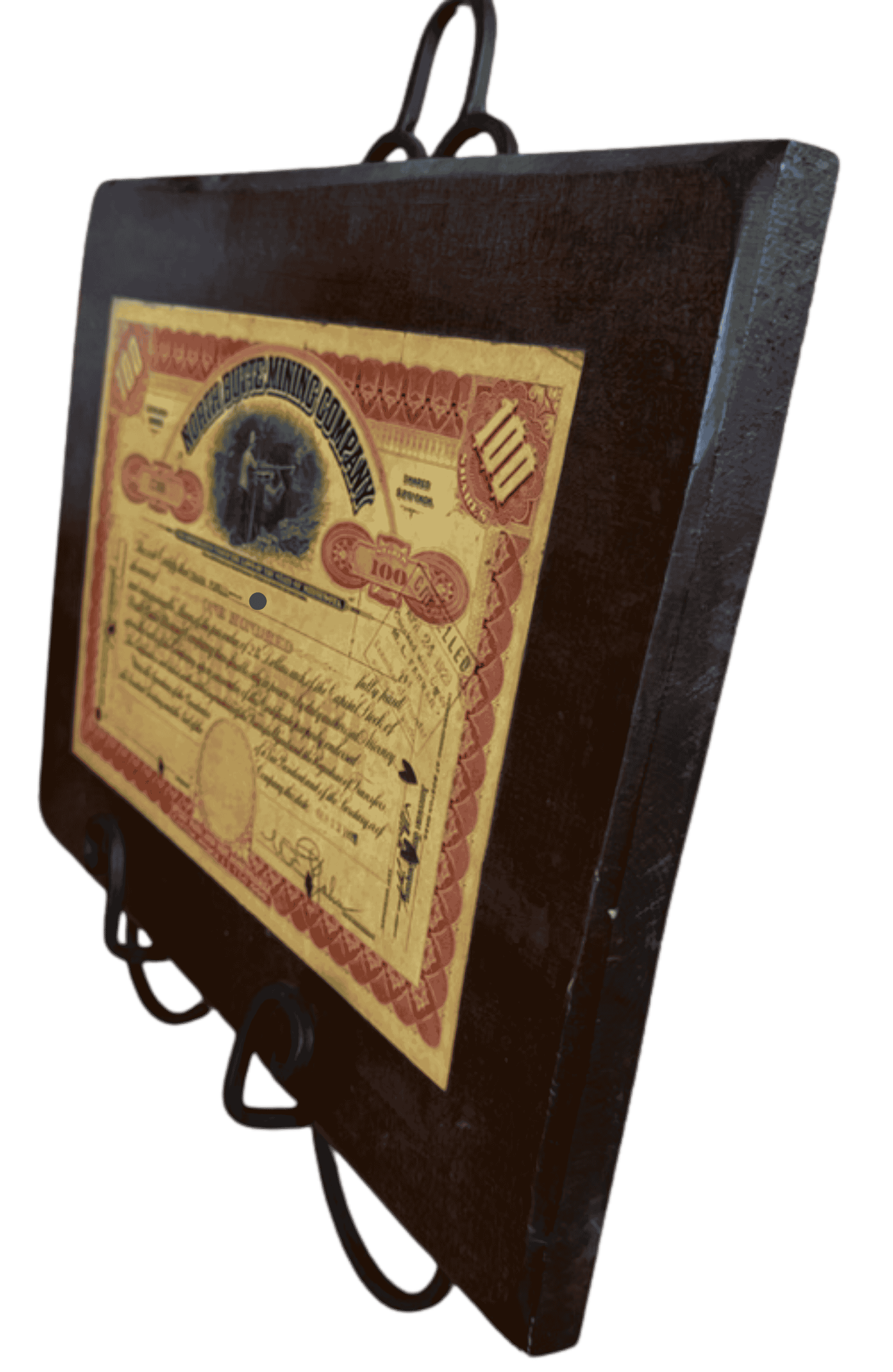 Side perspective of vintage North Butte Mining Company stock certificate plaque with mounted antique certificate on wooden backing.
