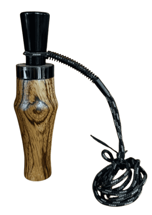 Close-up of zebrawood duck call barrel by J. Baker Louisiana showing bold striped grain and natural knot detail in the wood.