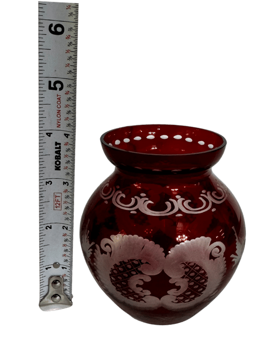 Vintage Bohemian-style ruby-flashed cut-to-clear glass vase beside a tape measure showing its overall height