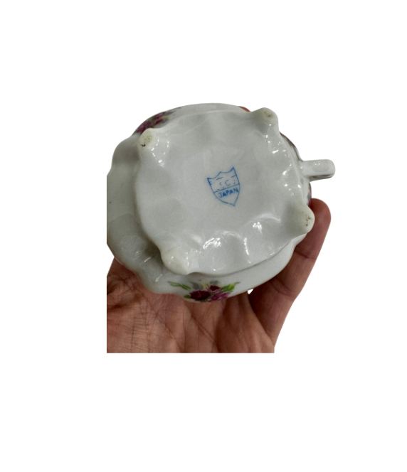 Underside of the floral porcelain creamer showing its four feet and blue ESCO Japan shield mark
