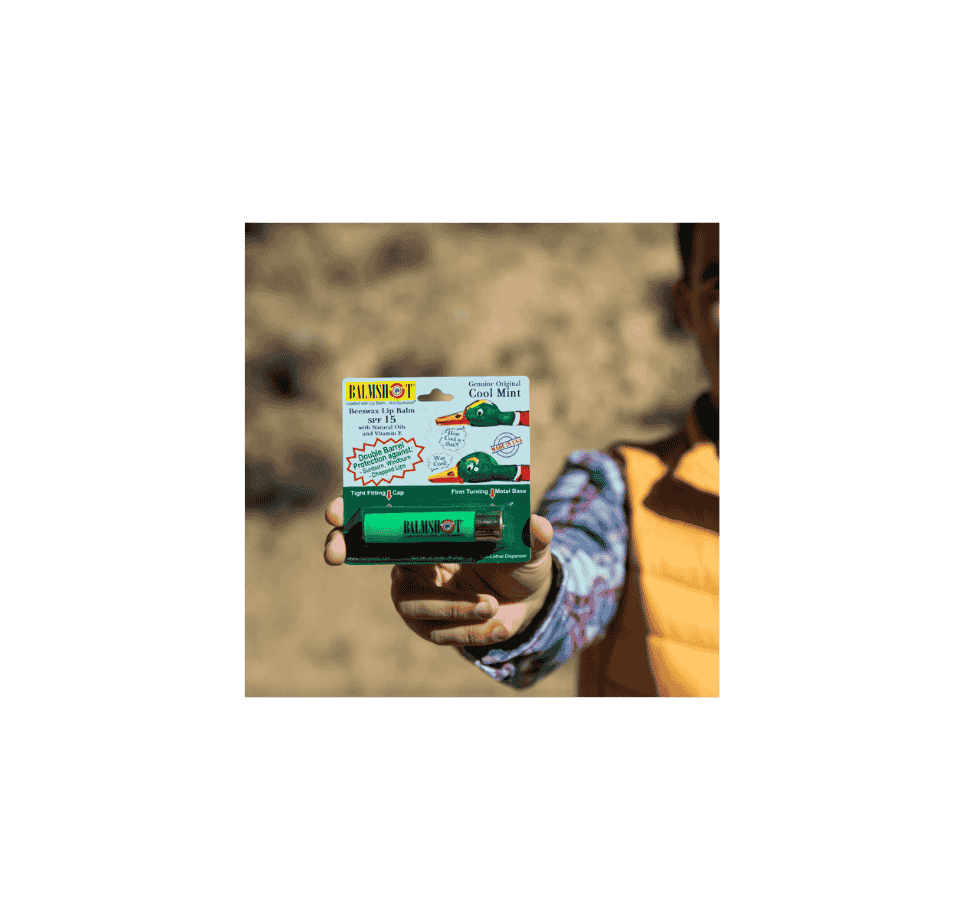 person holding balmshot cool mint lip balm in shotgun shell tube packaging outdoors