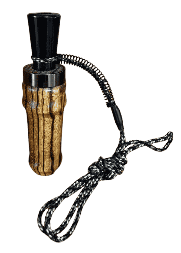 Close-up of zebrawood duck call barrel by J. Baker Louisiana showing bold dark striping across golden wood grain.