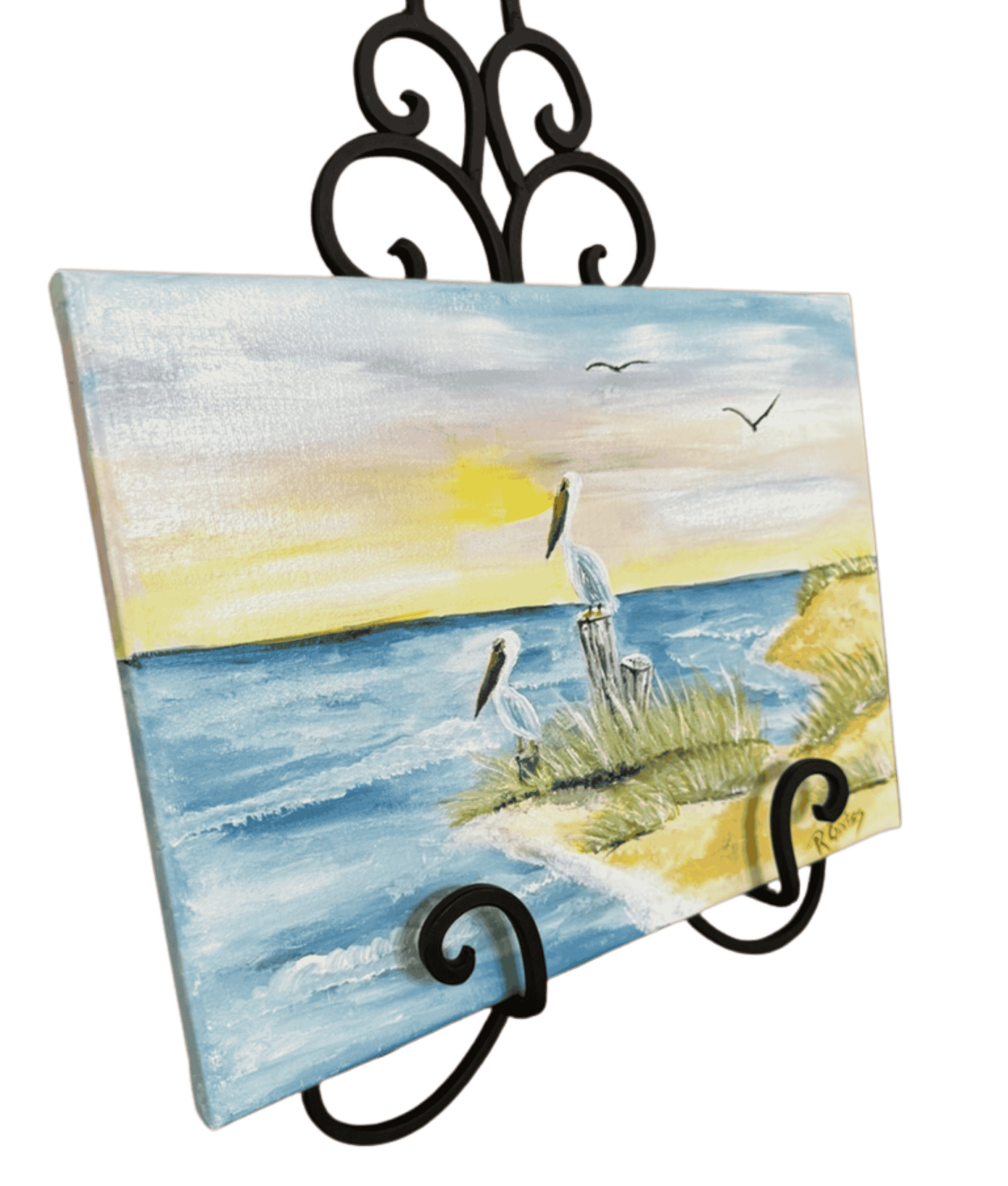 Original coastal bird painting by R. Gates showing two pelicans near the shoreline with beach grass, ocean waves, and warm sunset colors.