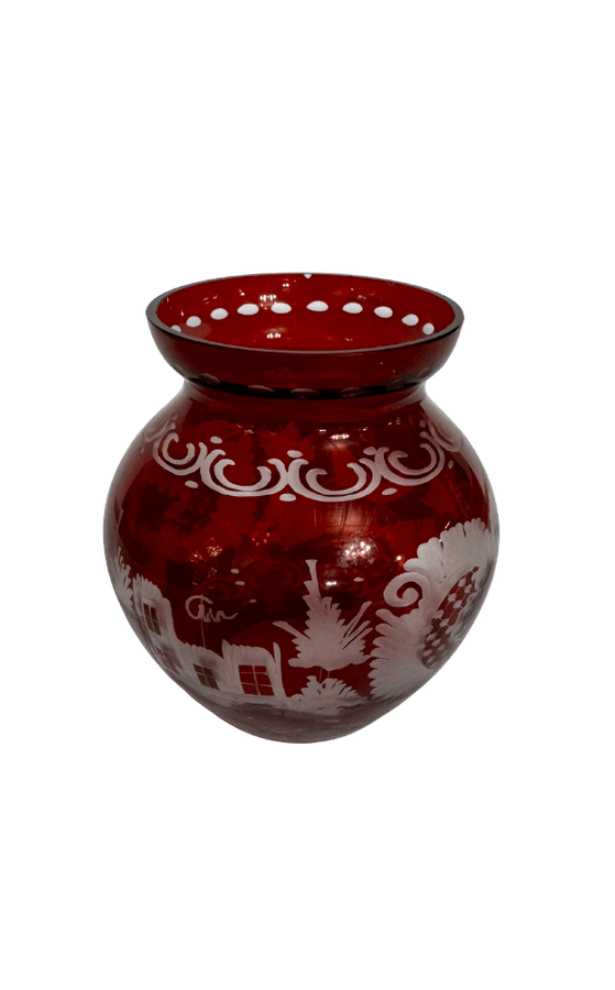 Side view of a vintage ruby-flashed cut-to-clear glass vase decorated with a cottage, trees, foliage, and scrollwork