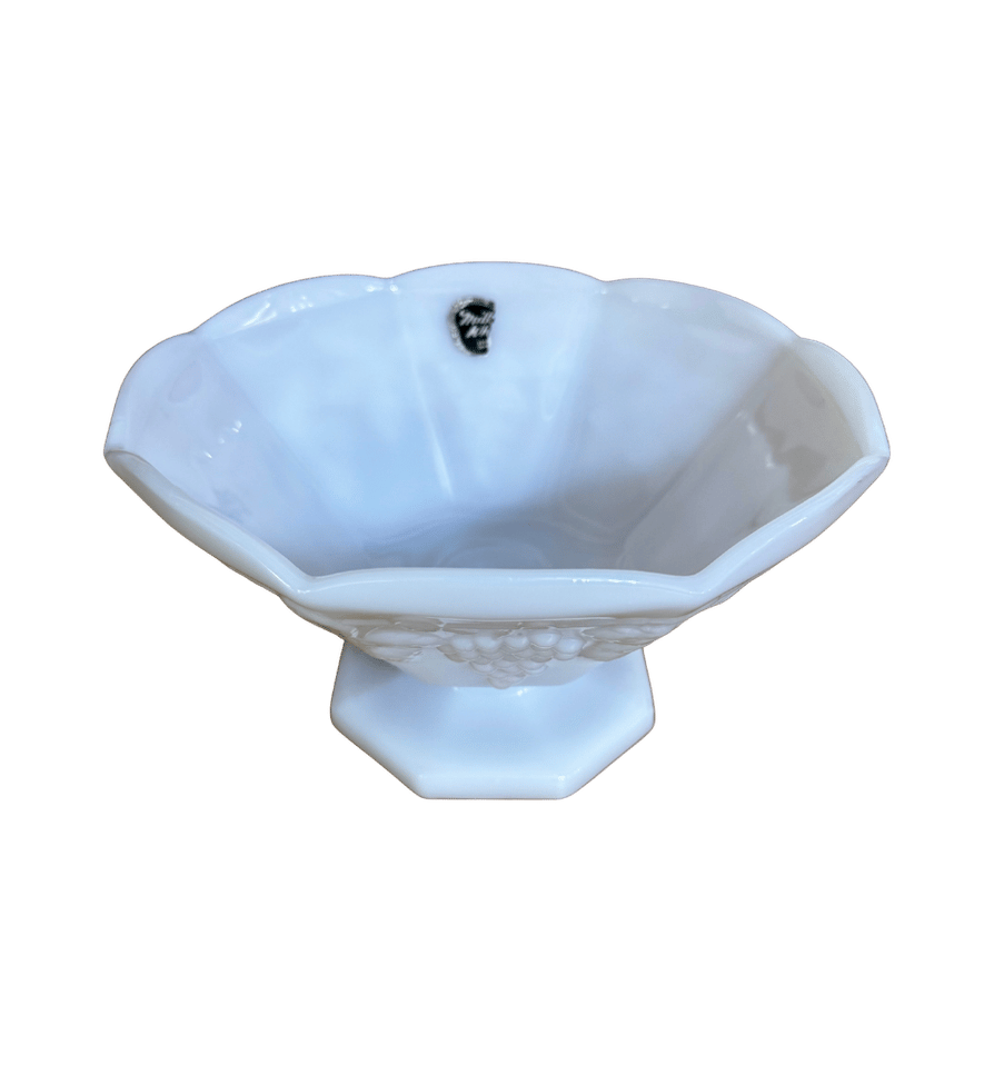 Top view of a vintage Anchor Hocking white milk glass pedestal bowl showing its scalloped rim and original foil label