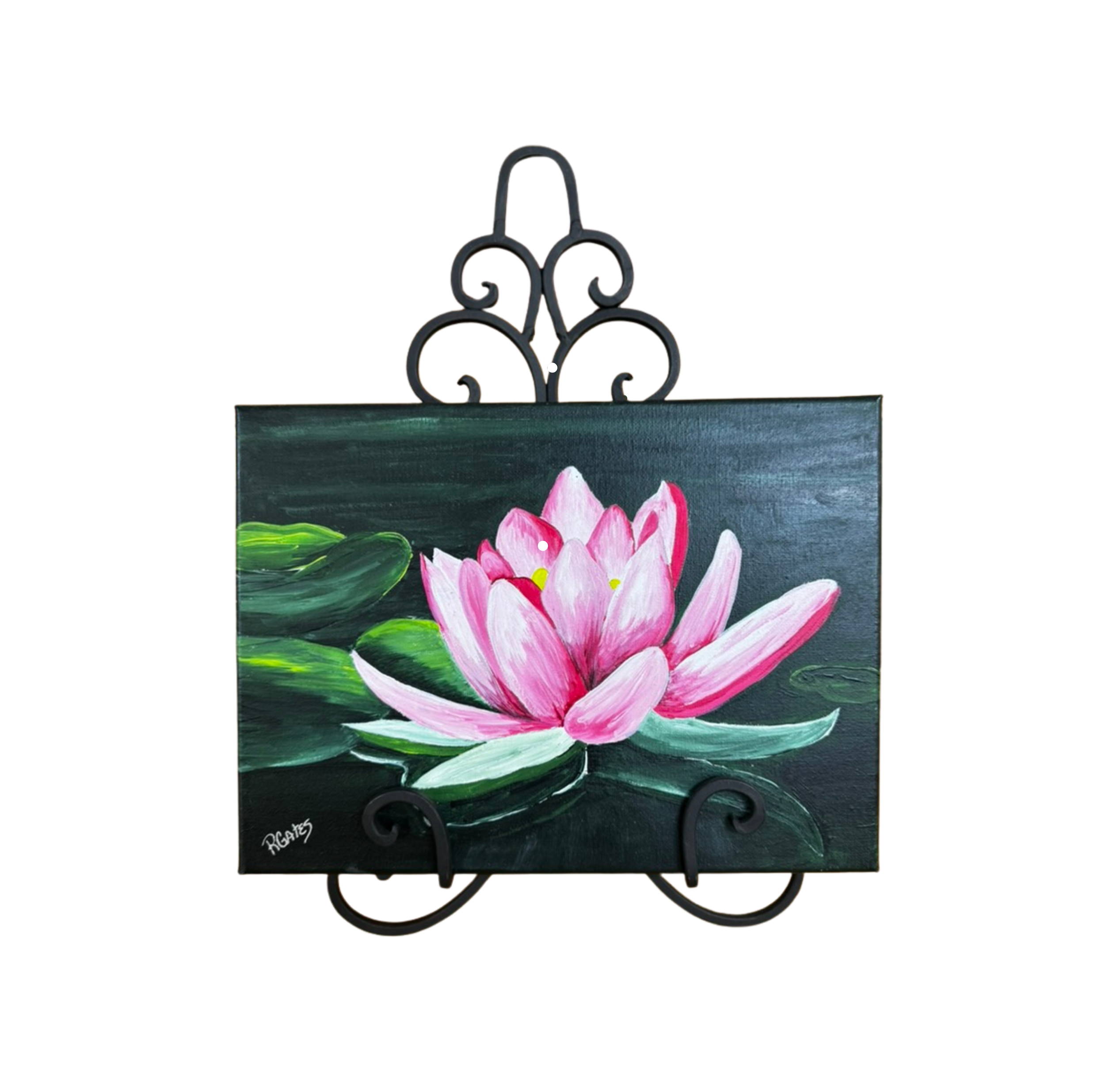 Lotus flower artwork displayed on an easel showcasing a pink lotus blossom surrounded by lily pads and calm water in rich botanical colors.