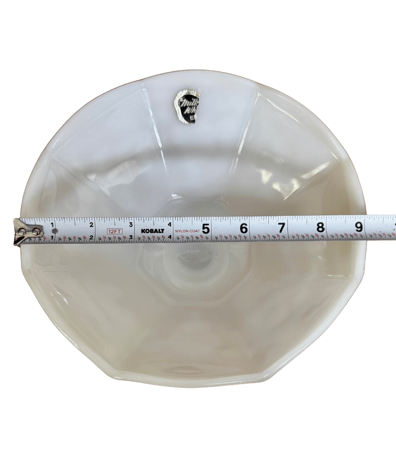 Top view of a vintage Anchor Hocking milk glass pedestal bowl with a tape measure showing its approximate 9-inch diameter