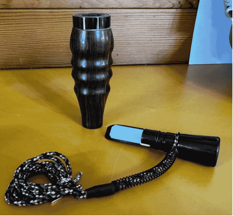 Hand-turned Bocote wood single reed duck call with ribbed barrel and braided lanyard handcrafted by Louisiana call maker J. Baker.