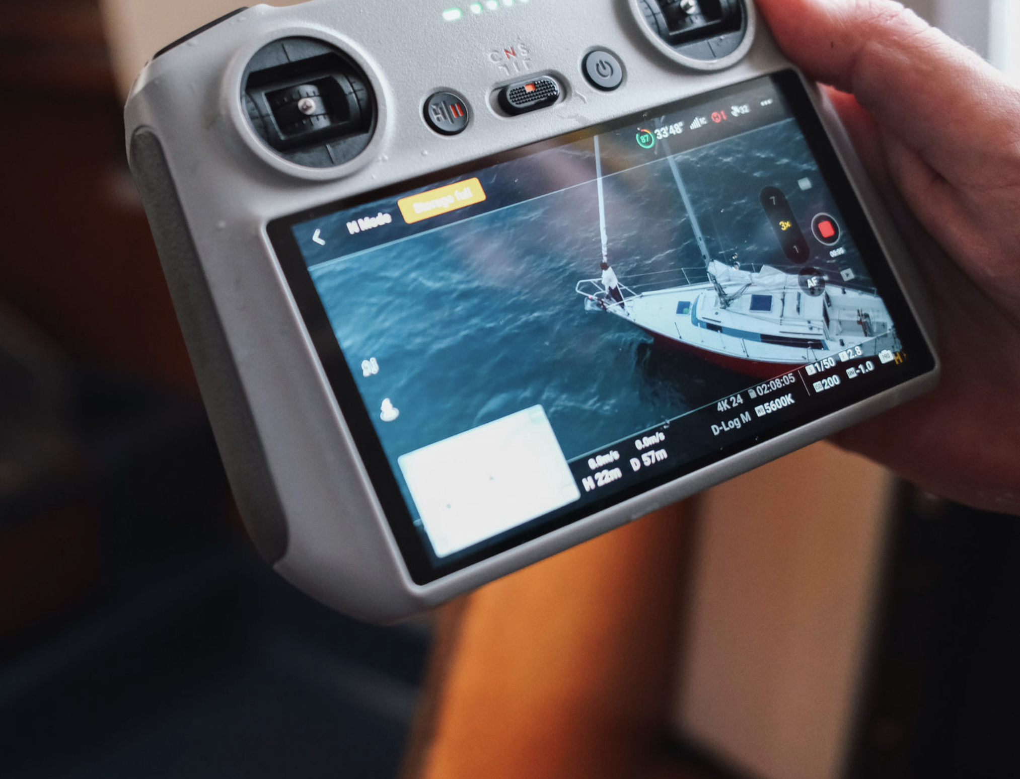 Close-up of a camera screen showing a photo of a sailboat on water.