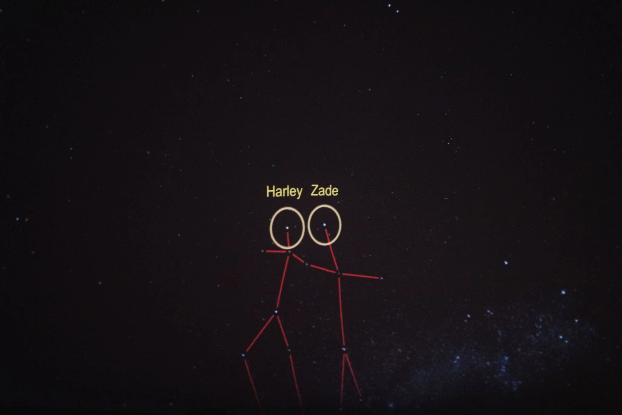 Night sky with stars, featuring a constellation outlined with red lines and labeled 'Harley Zade' and 'Zade' in yellow text, with two circled star groups.