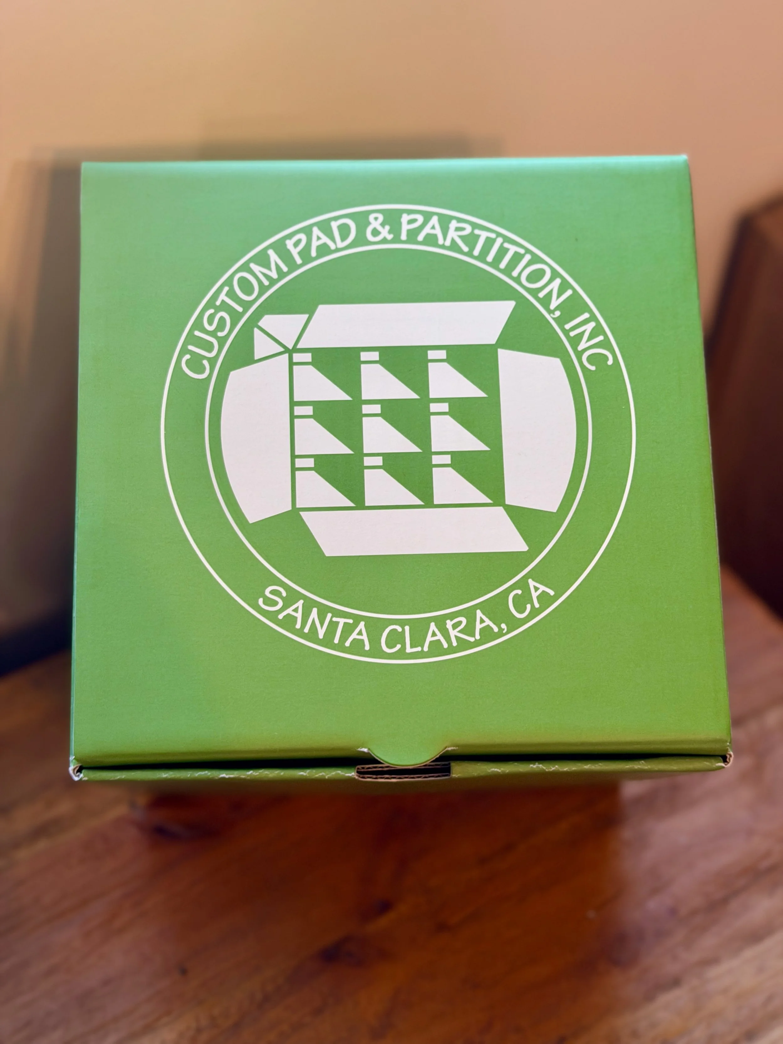 Custom printed gift box 'Custom Pad & Partition, Inc. Santa Clara, CA'.