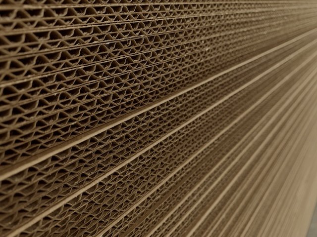 Close-up of corrugated cardboard sheets stacked together.