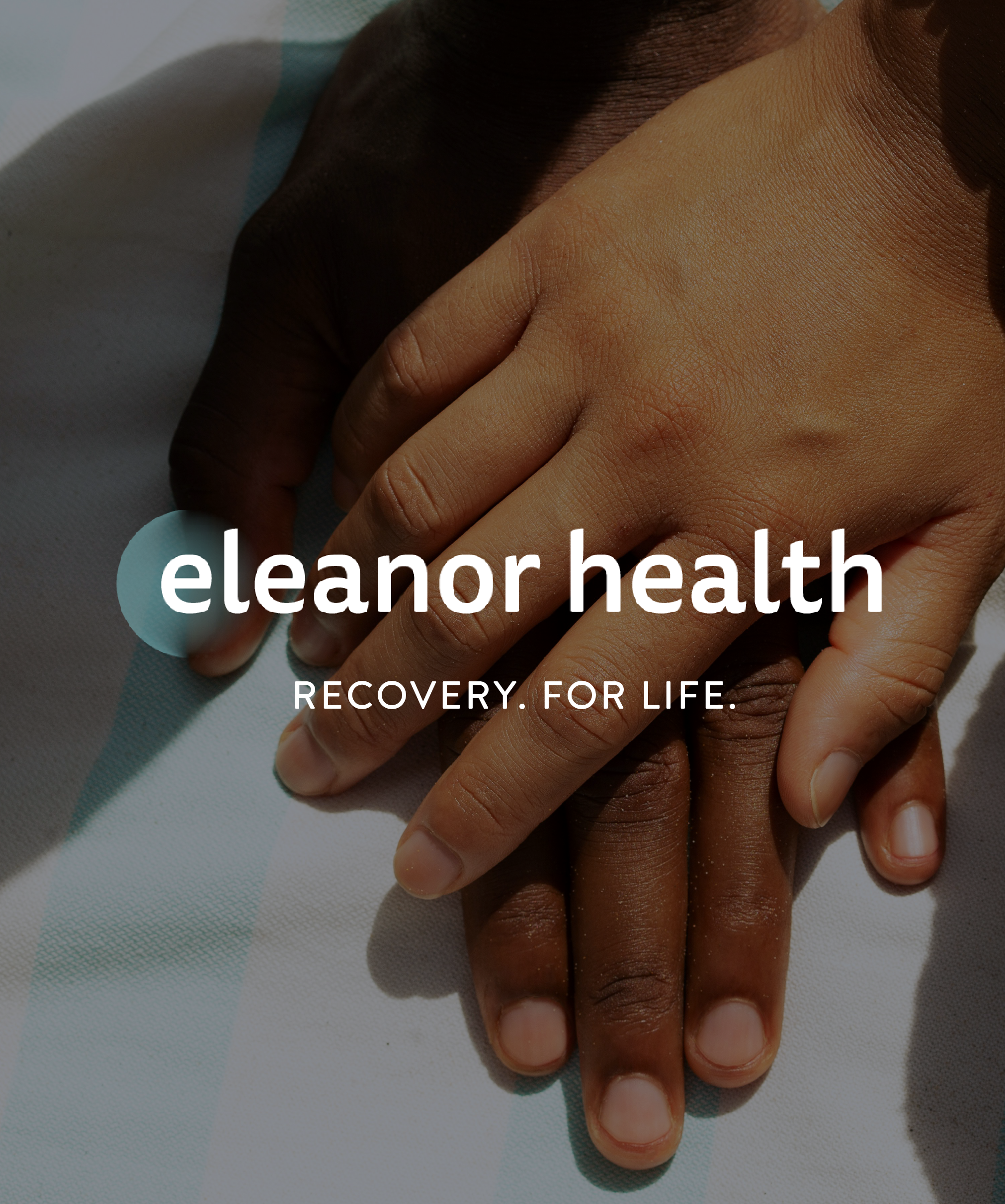 Close-up of two hands, one light-skinned and one dark-skinned, holding each other on a medical bed. Overlaid text reads 'eleanor health' and 'RECOVERY. FOR LIFE.'