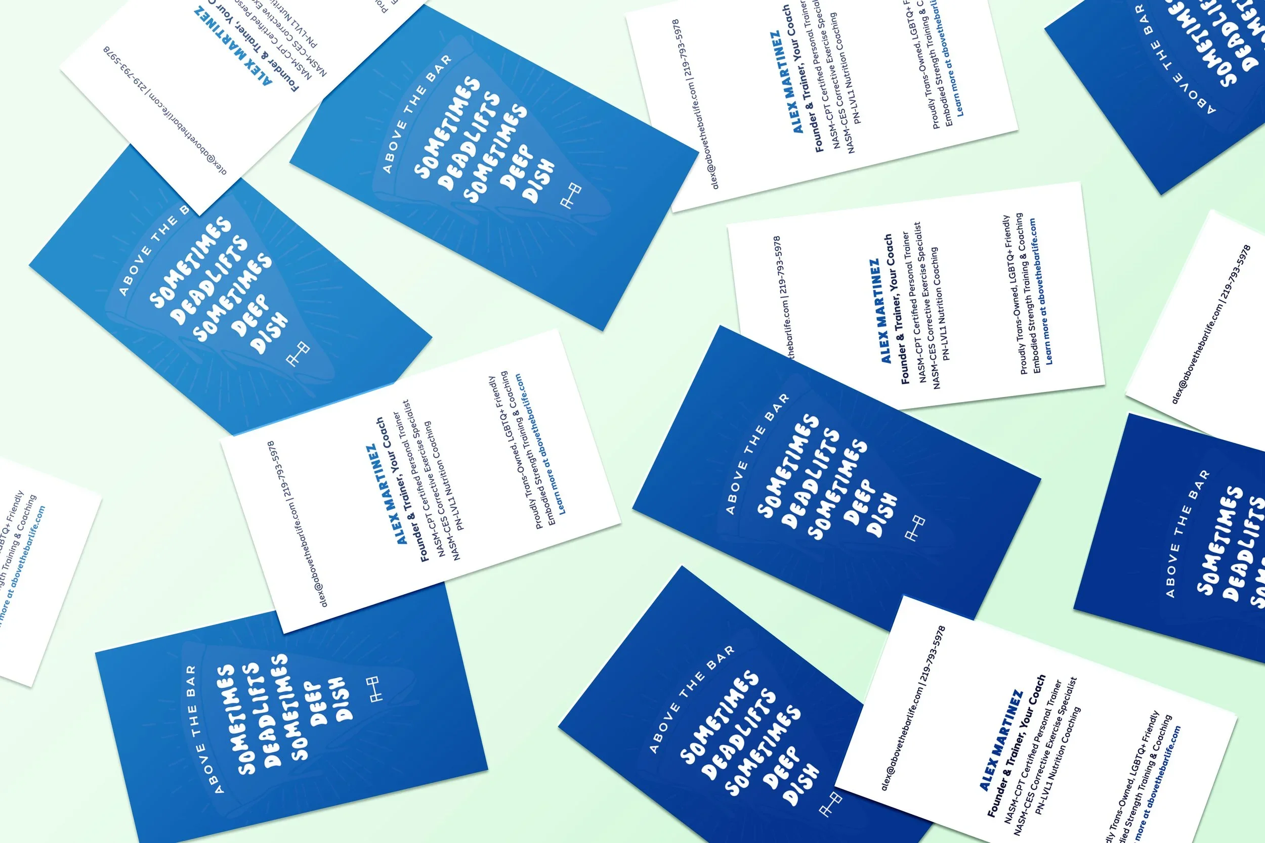 Business cards scattered on a surface, with some blue and white cards featuring text.