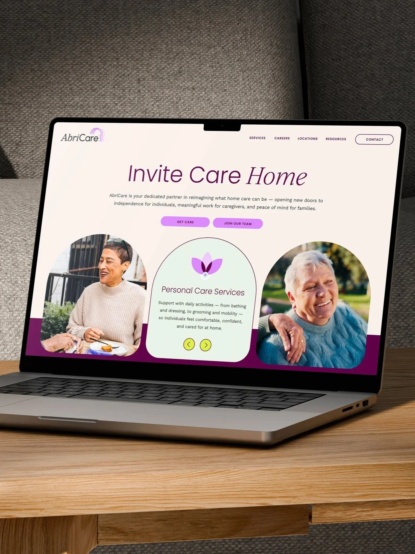 Laptop on a wooden table displaying a website for AbriCare with a message 'Invite Care Home' and images of elderly individuals.