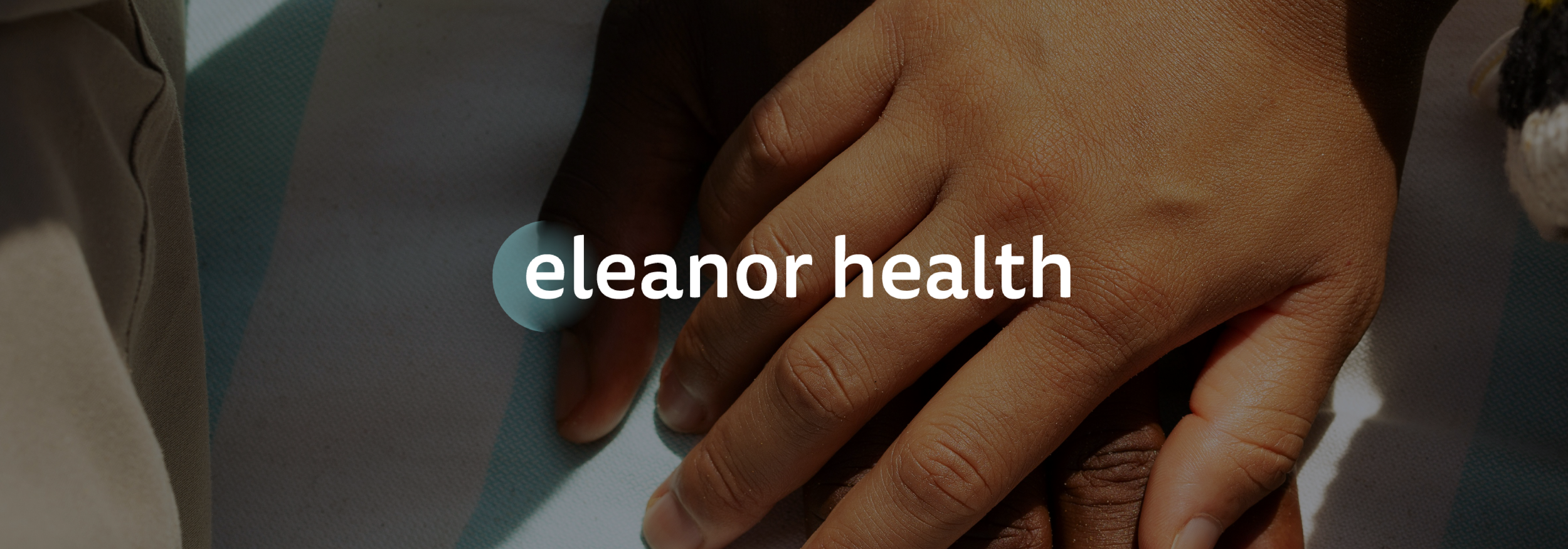 Close-up of two hands, one with darker skin, resting on a surface with the text 'eleanor health' overlayed.