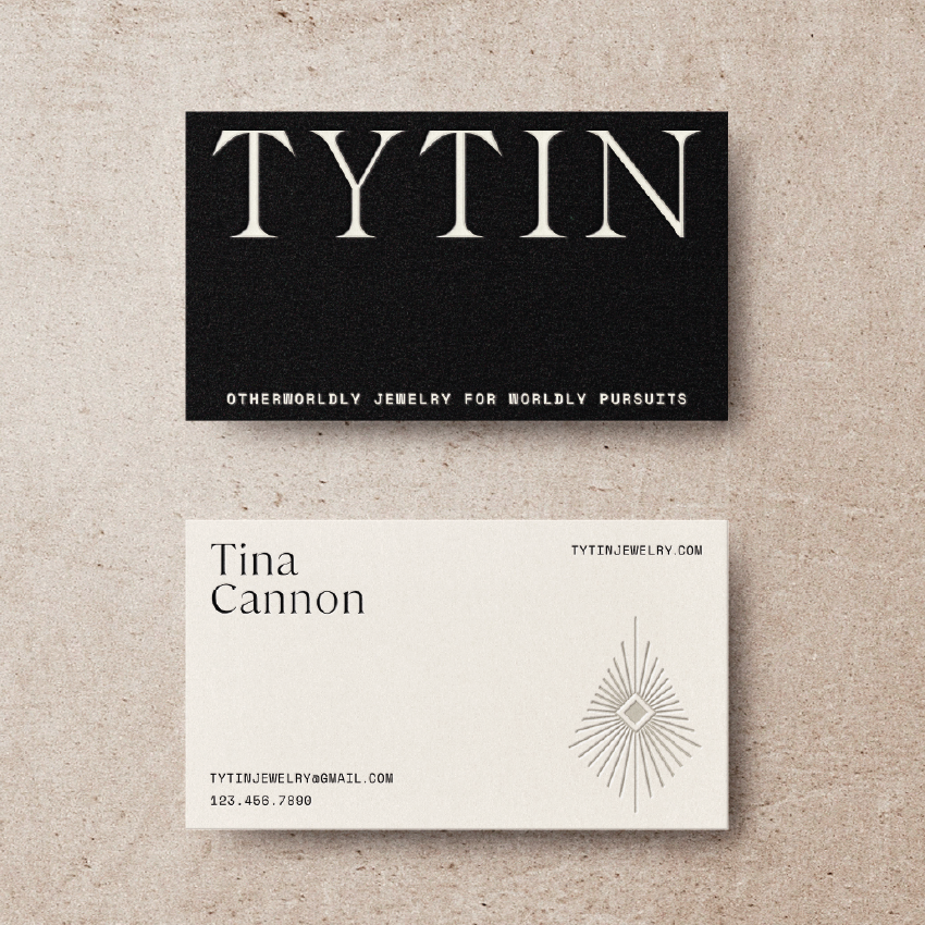 A business card with contact information, placed below a black card that reads "TYTIN" with the slogan "Otherworldly Jewelry for Worldly Pursuits".
