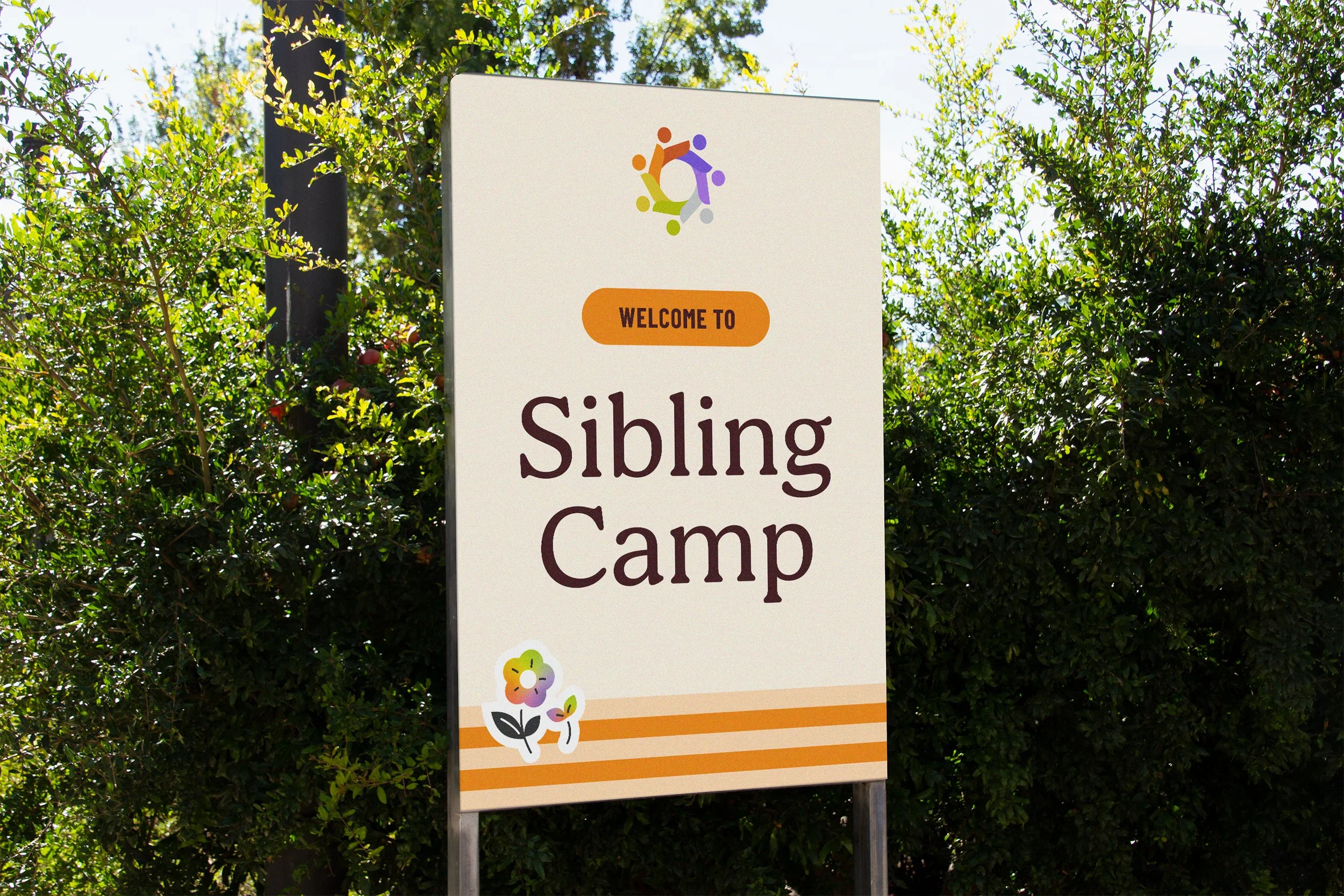 Sign welcoming visitors to Sibling Camp, with colorful logo at the top, floral decoration at the bottom, and a background of green bushes.