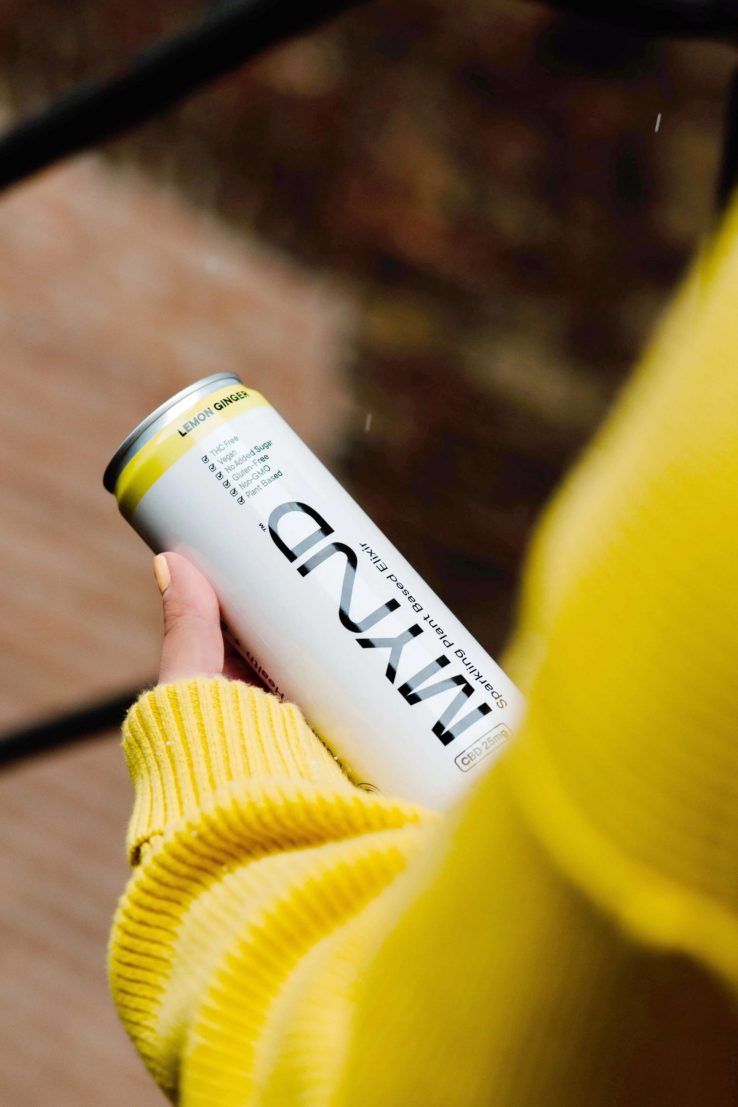 A hand holding a can of MYND Sparkling Plant Based Elixer