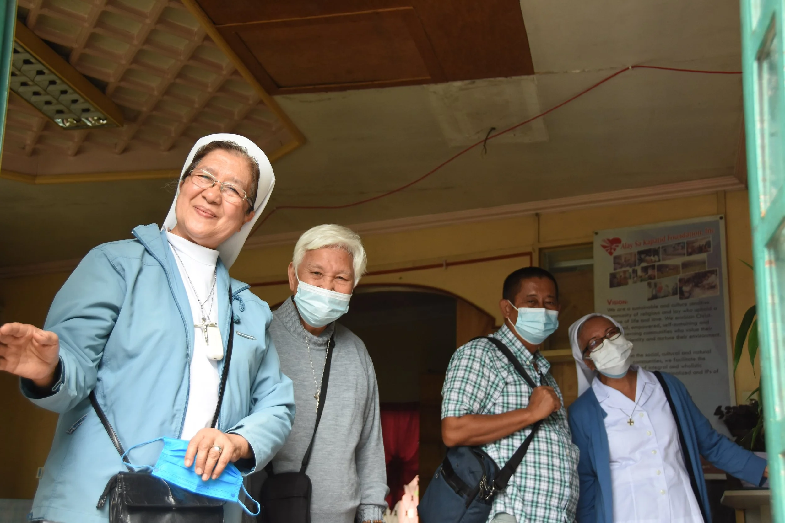 Local faith leaders wave to a camera during visits to water access sites outside Baguio City, in the Philippines.