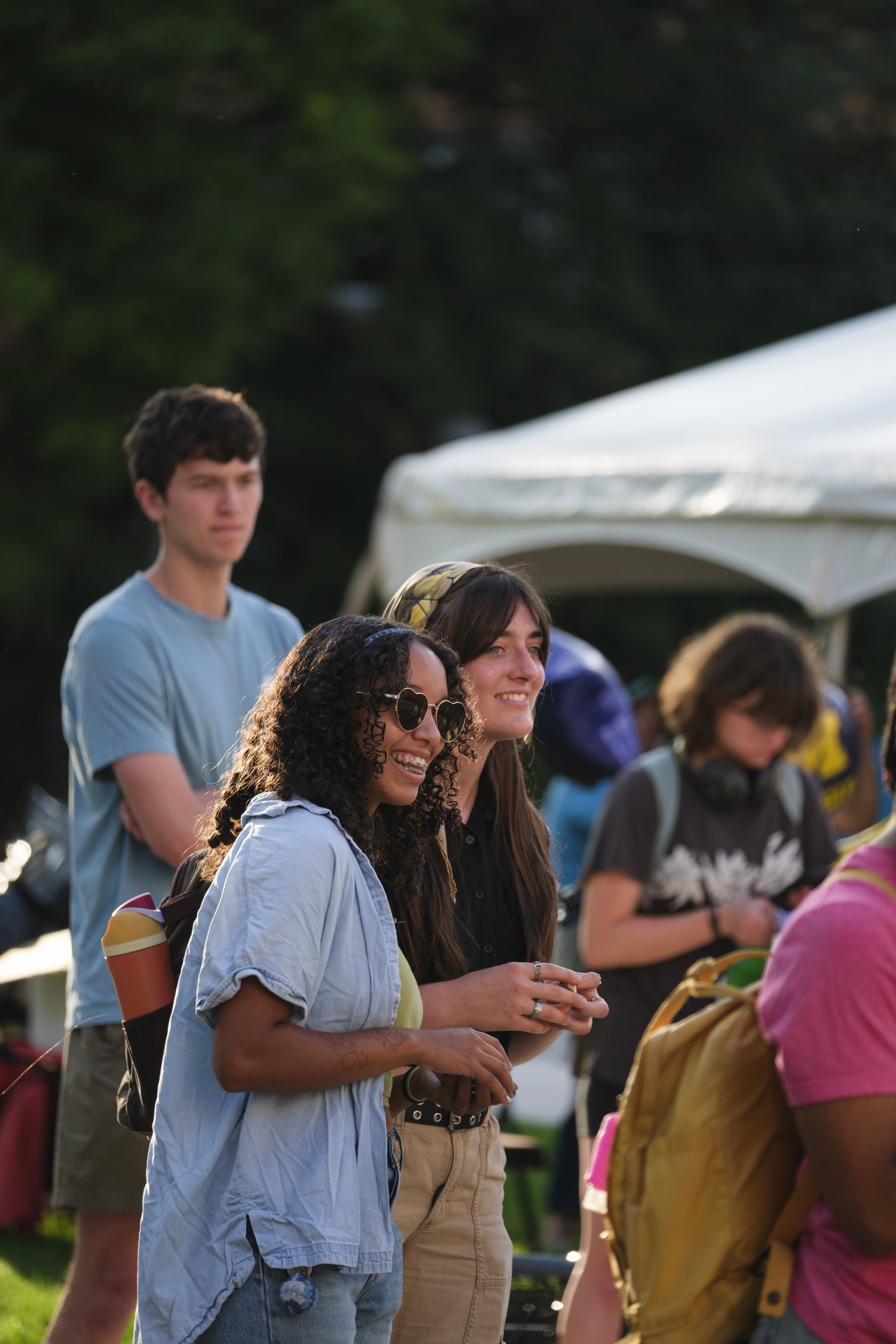 A group of students smile while watching performances taking place during Artscapade at the University of Michigan Museum of Art.