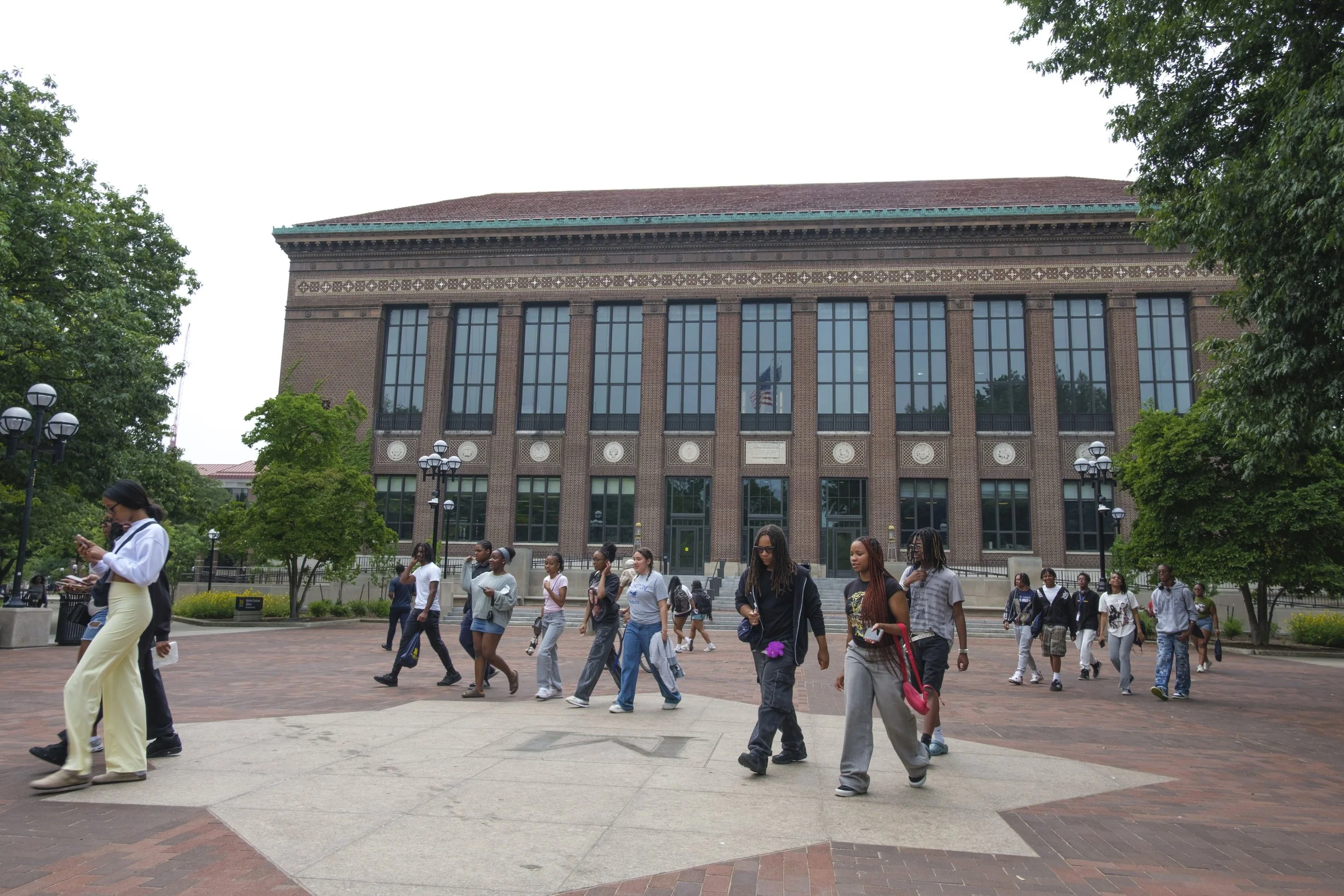 A group of high school students participating in the Discover U program at the University of Michigan walk at the Diag on campus.