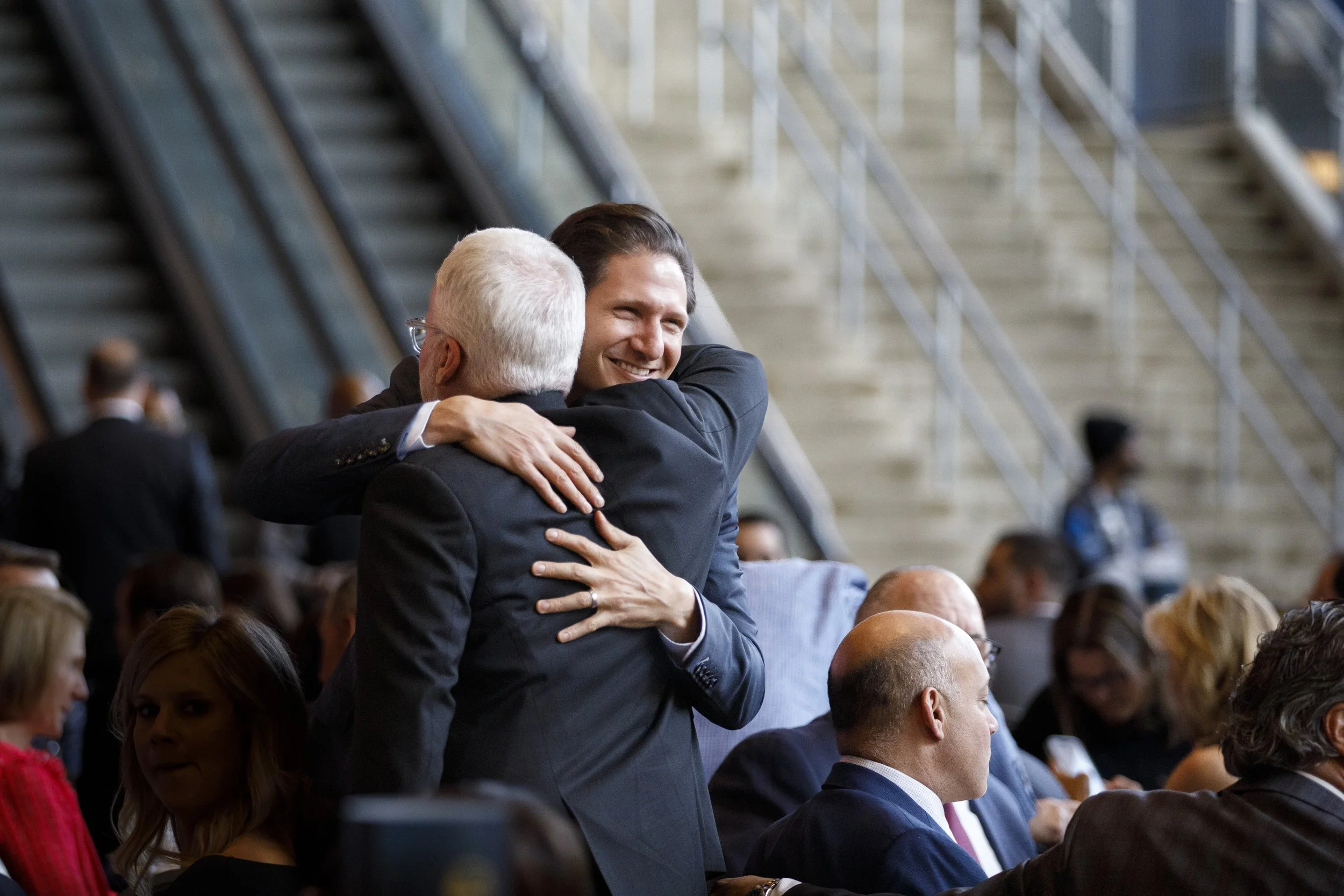Two men hug in a crowd of people.