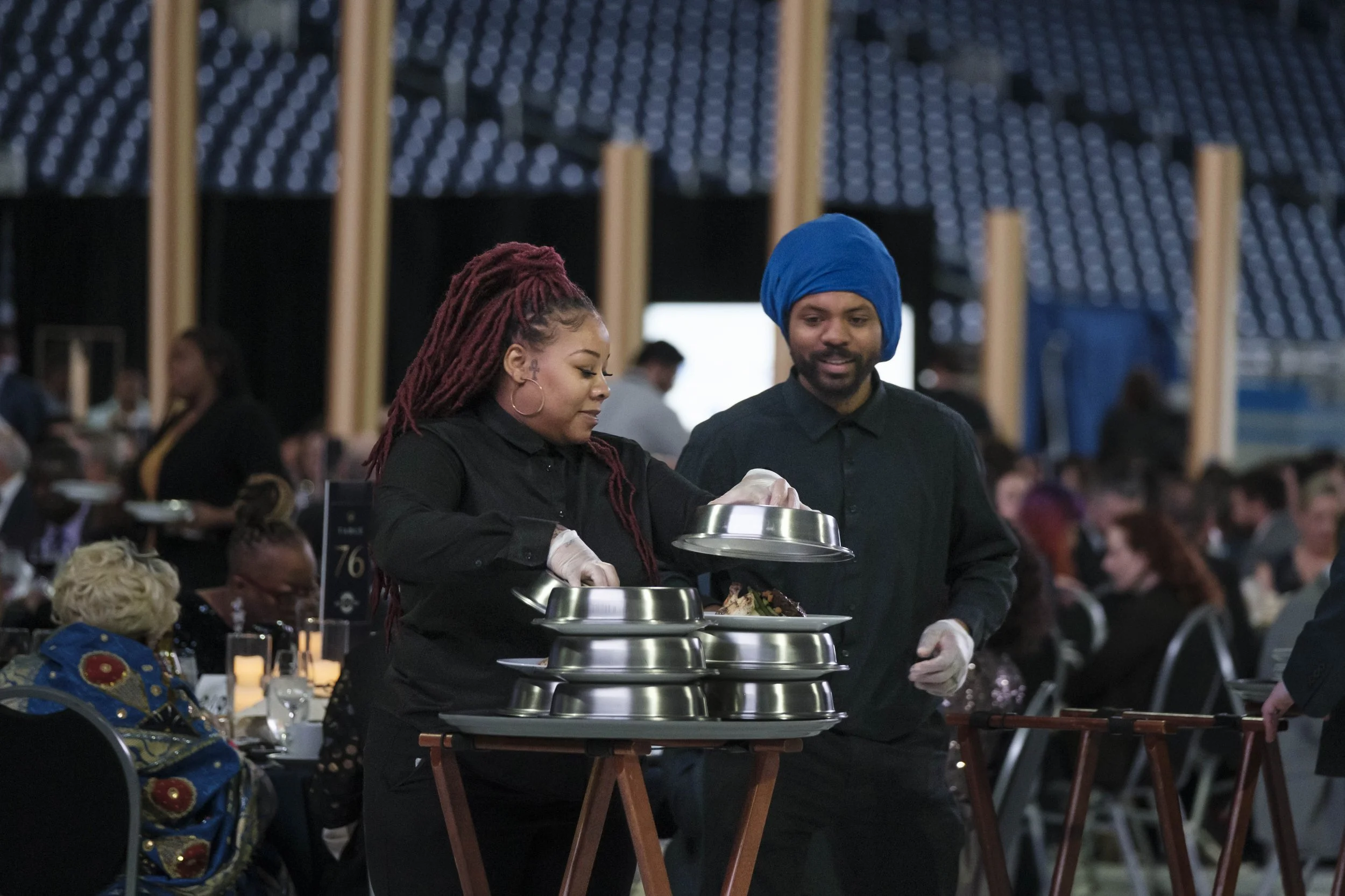 Two catering servers open lids to stacked plates.