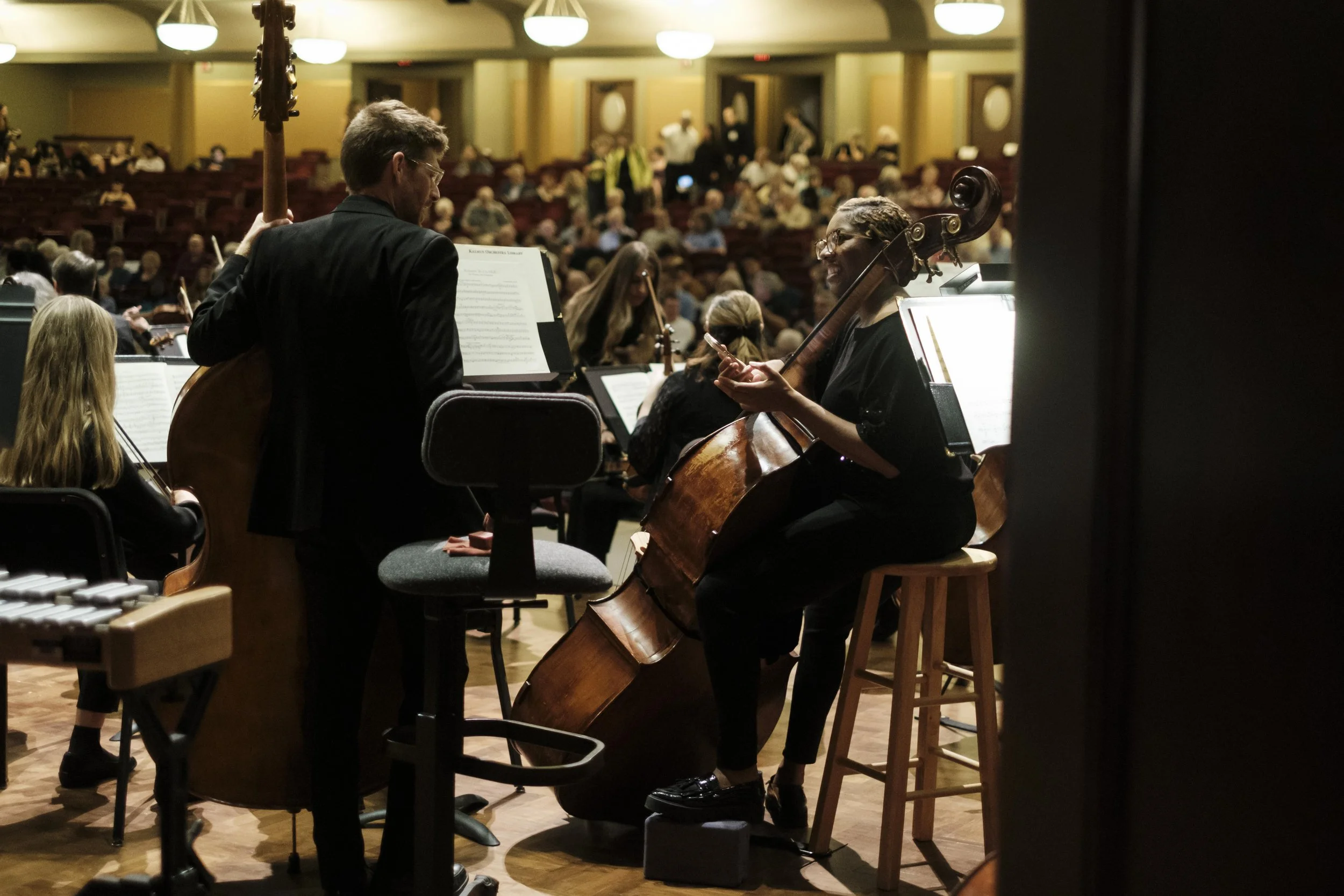 Musicians talking onstage before the start of a concert.