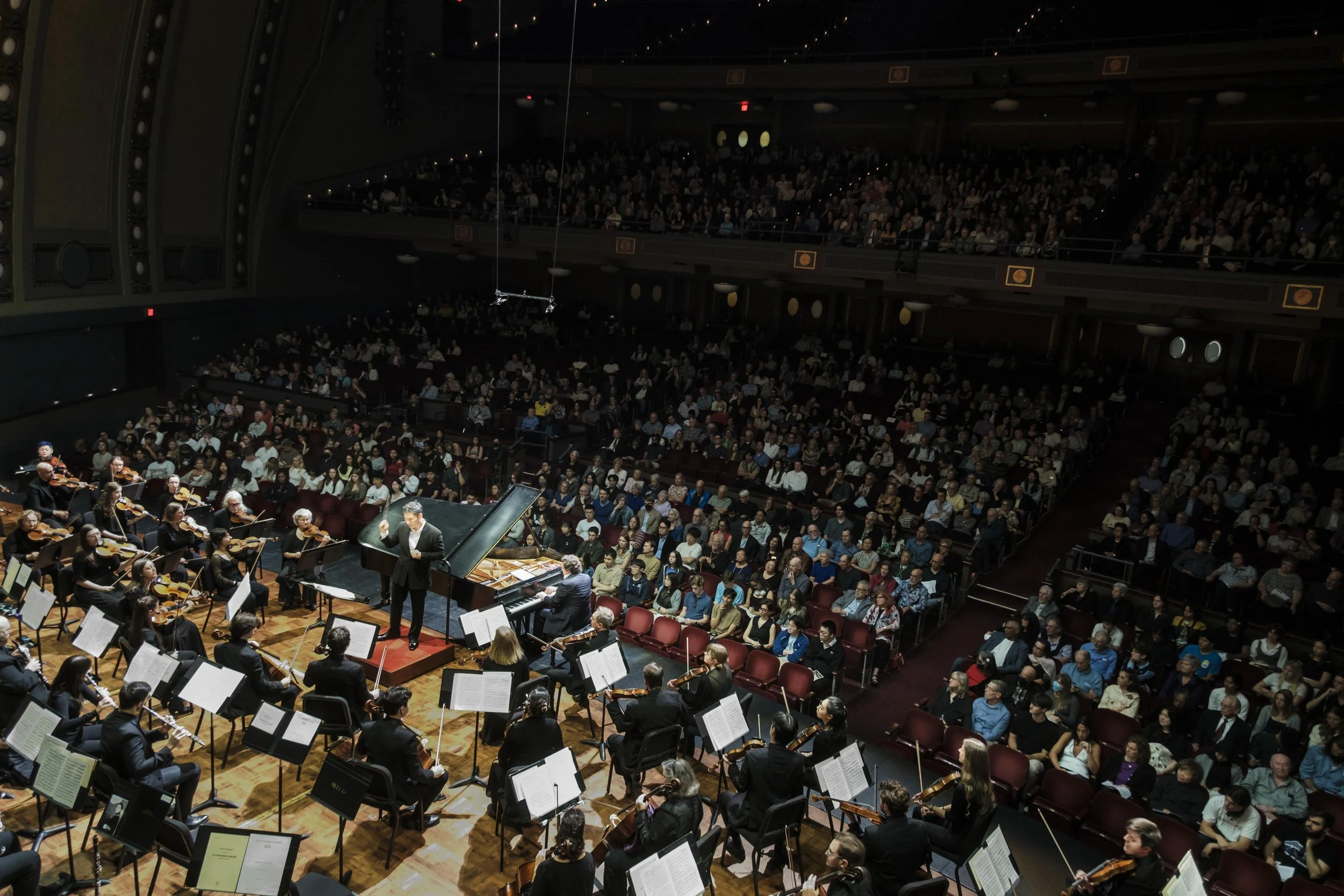 Conductor Earl Lee leading the Ann Arbor Symphony Orchestra onstage during a performance.