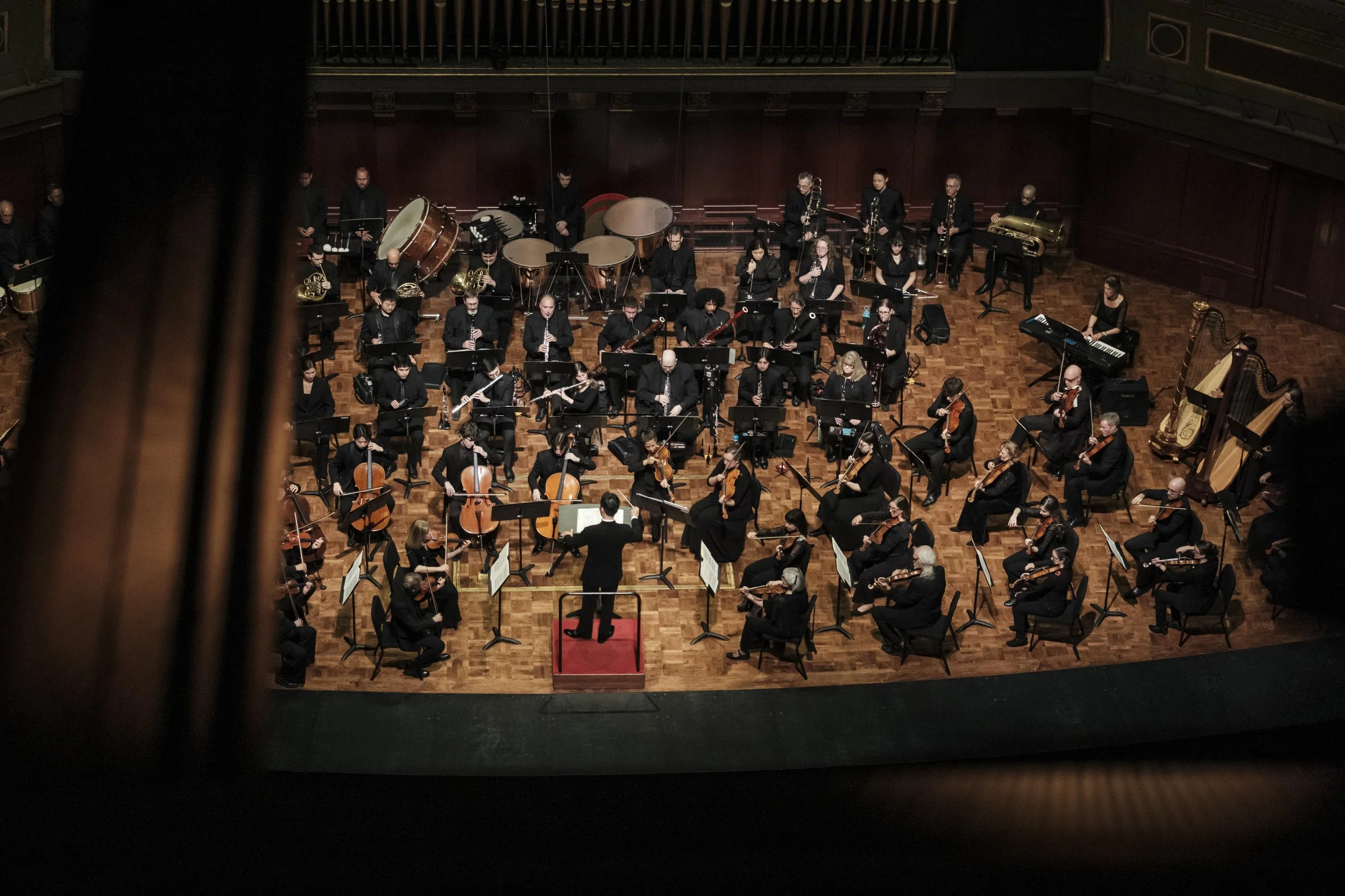 A high perspective looking down at the stage while the Ann Arbor Symphony Orchestra performs on stage.