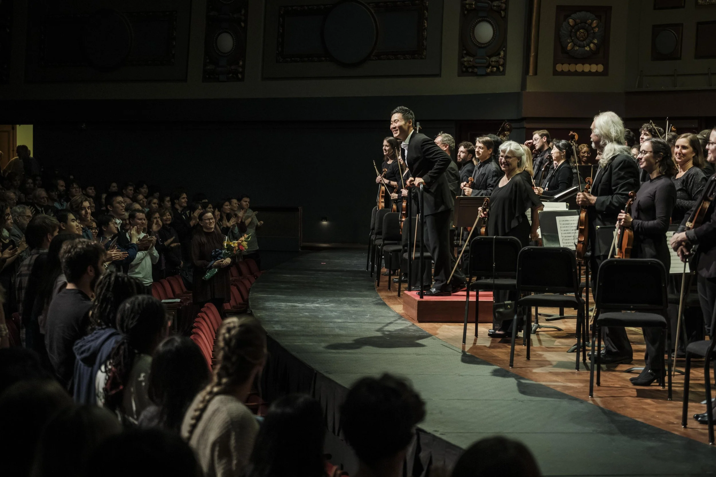 Conductor Earl Lee on stage smiling at the audience after a performance with the Ann Arbor Symphony Orchestra.