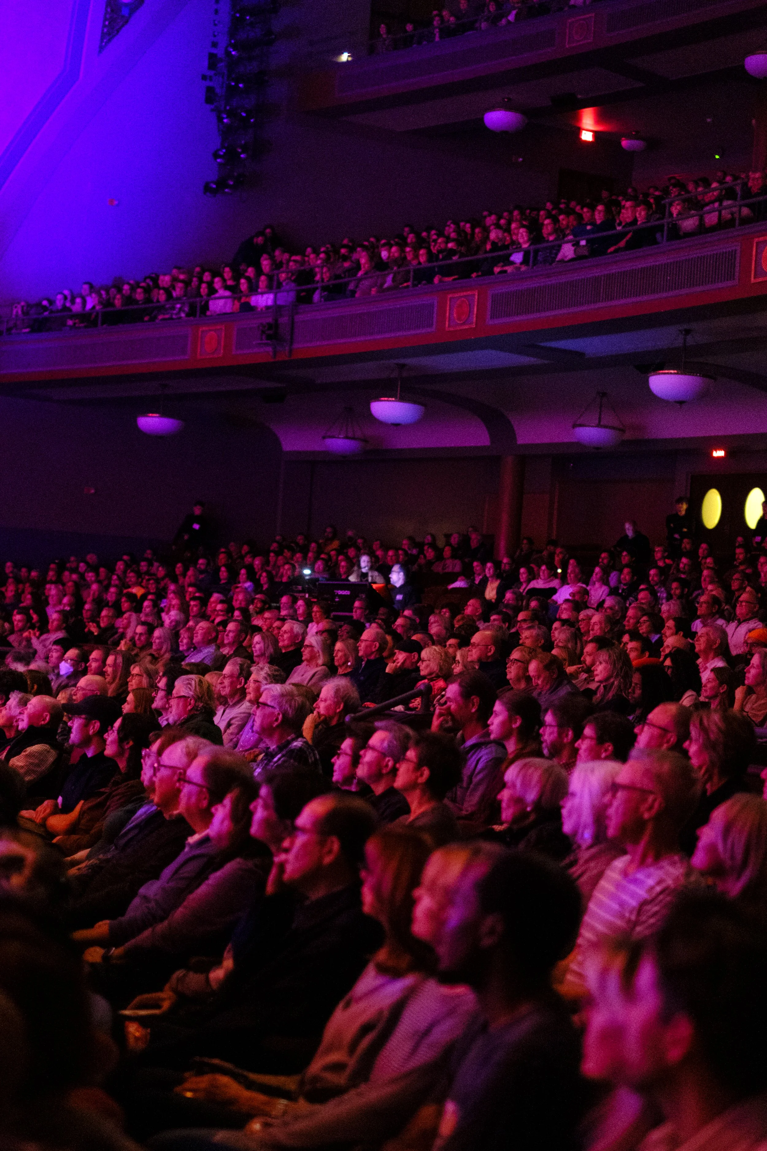 An audience listening to Jacob Collier performing with the Ann Arbor Symphony Orchestra at Hill Auditorium.