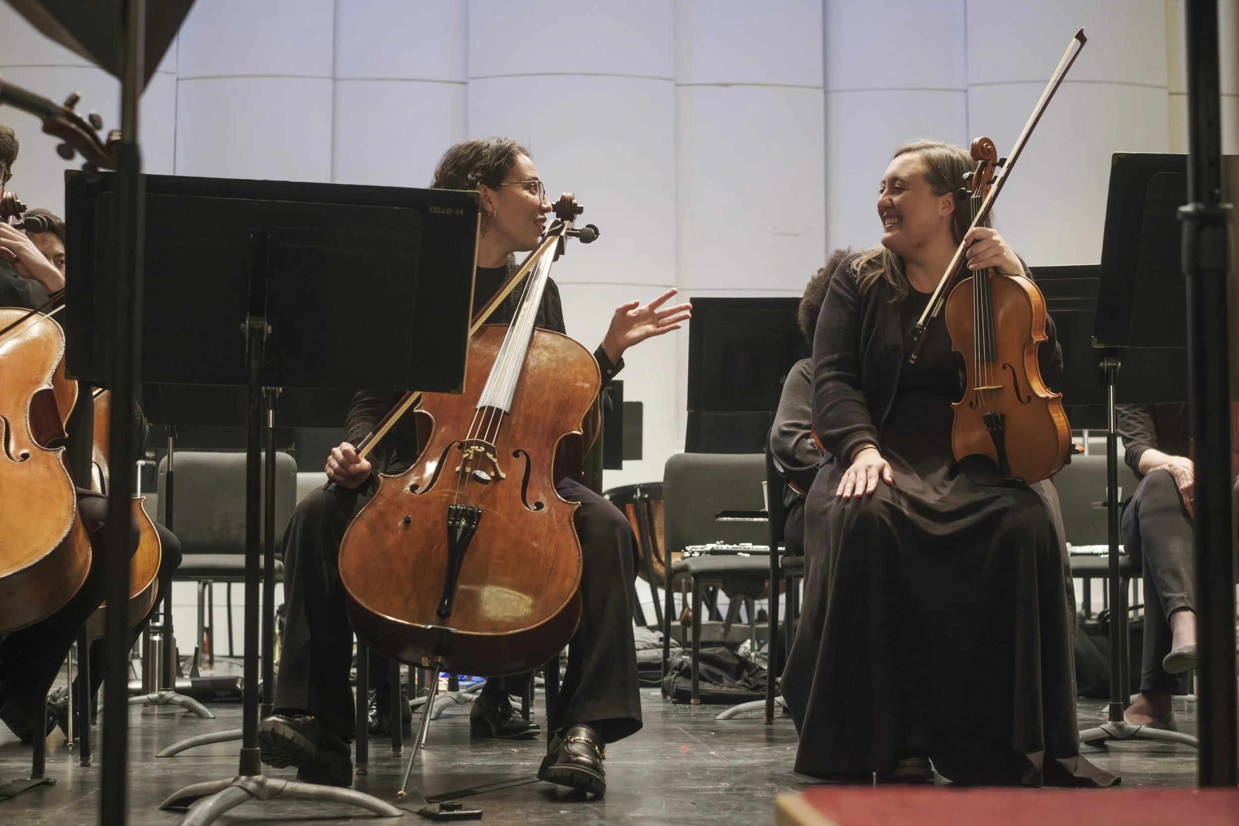 Two musicians talking with one another onstage at the Michigan Theater before the start of the symphony concert.