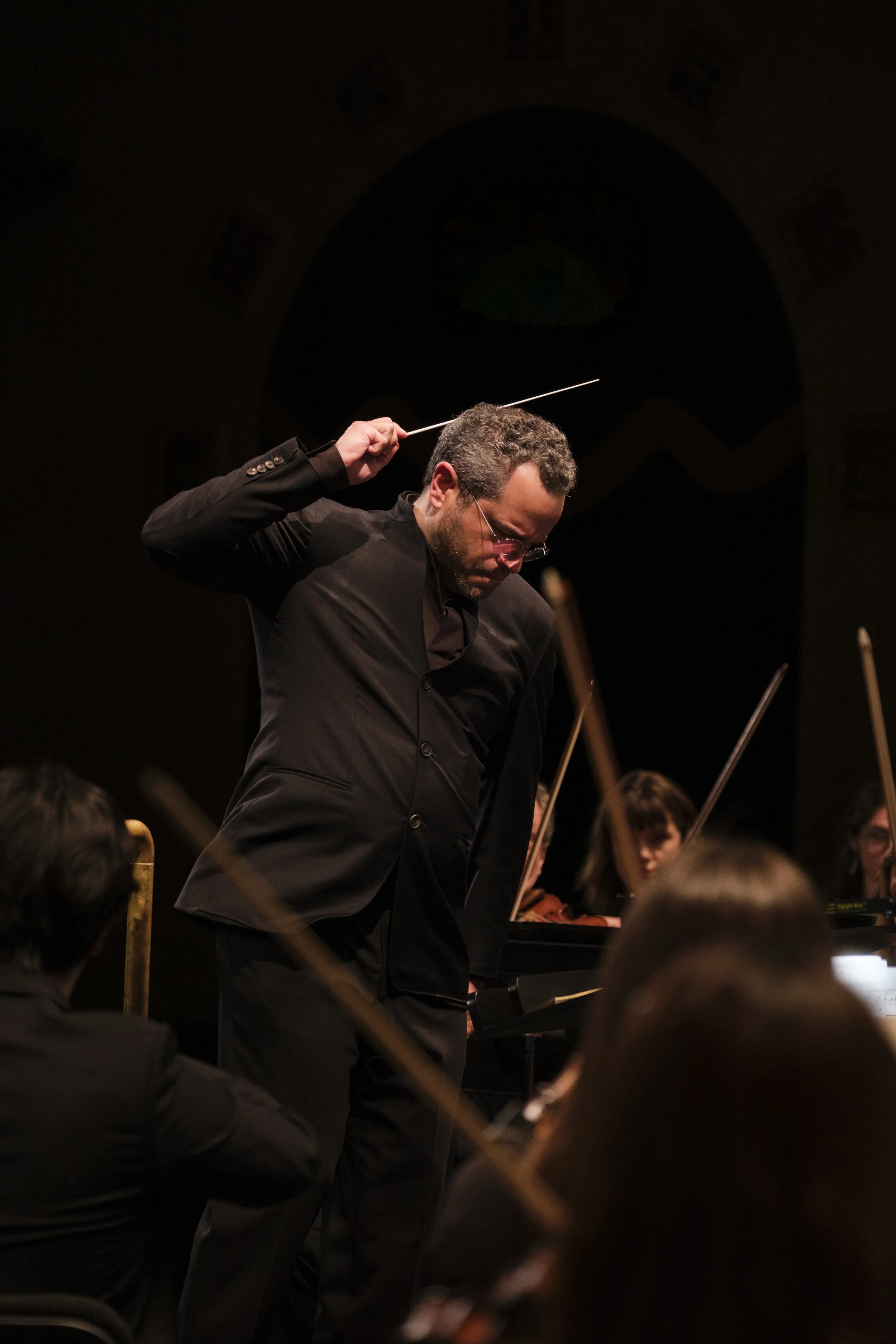 Conductor Andrew Grams on stage during a concert.