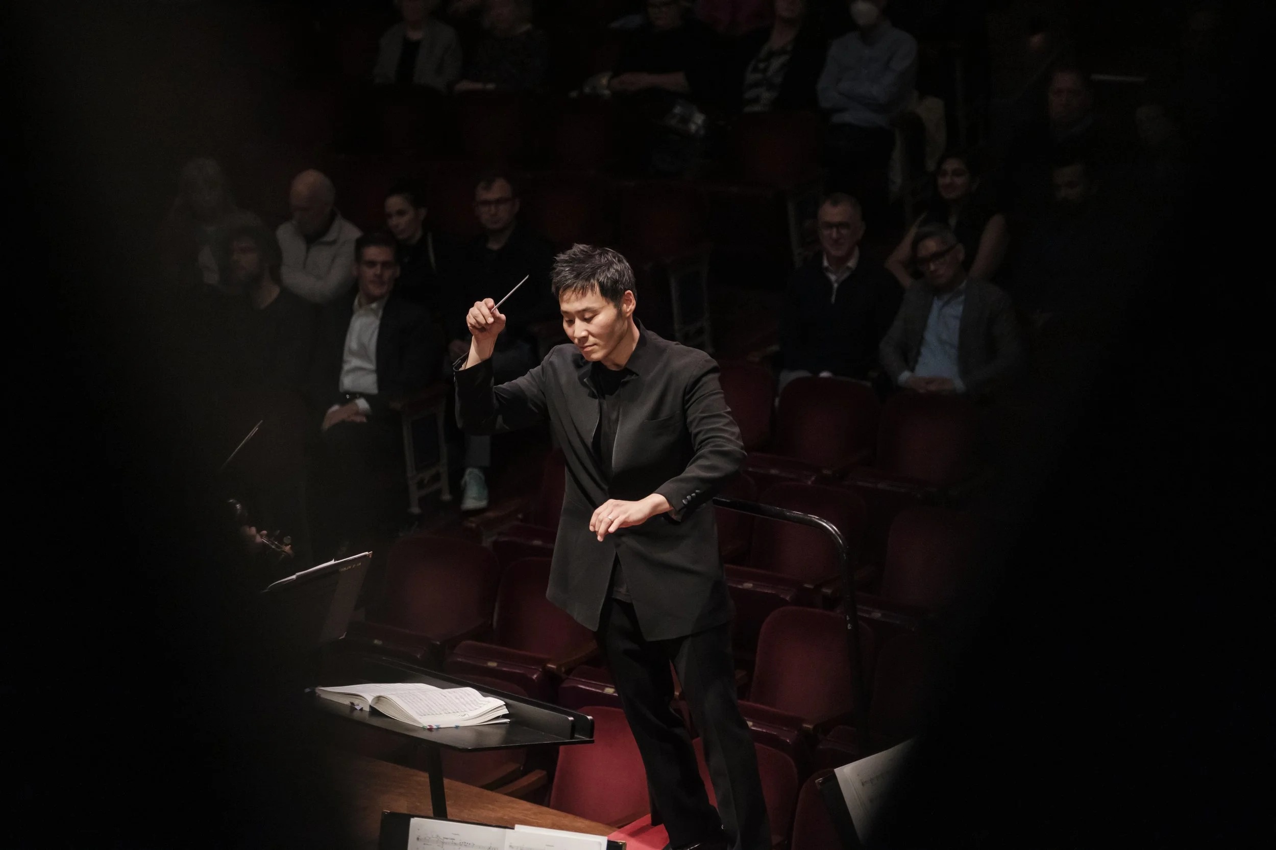Conductor Earl Lee on stage during a concert performance.