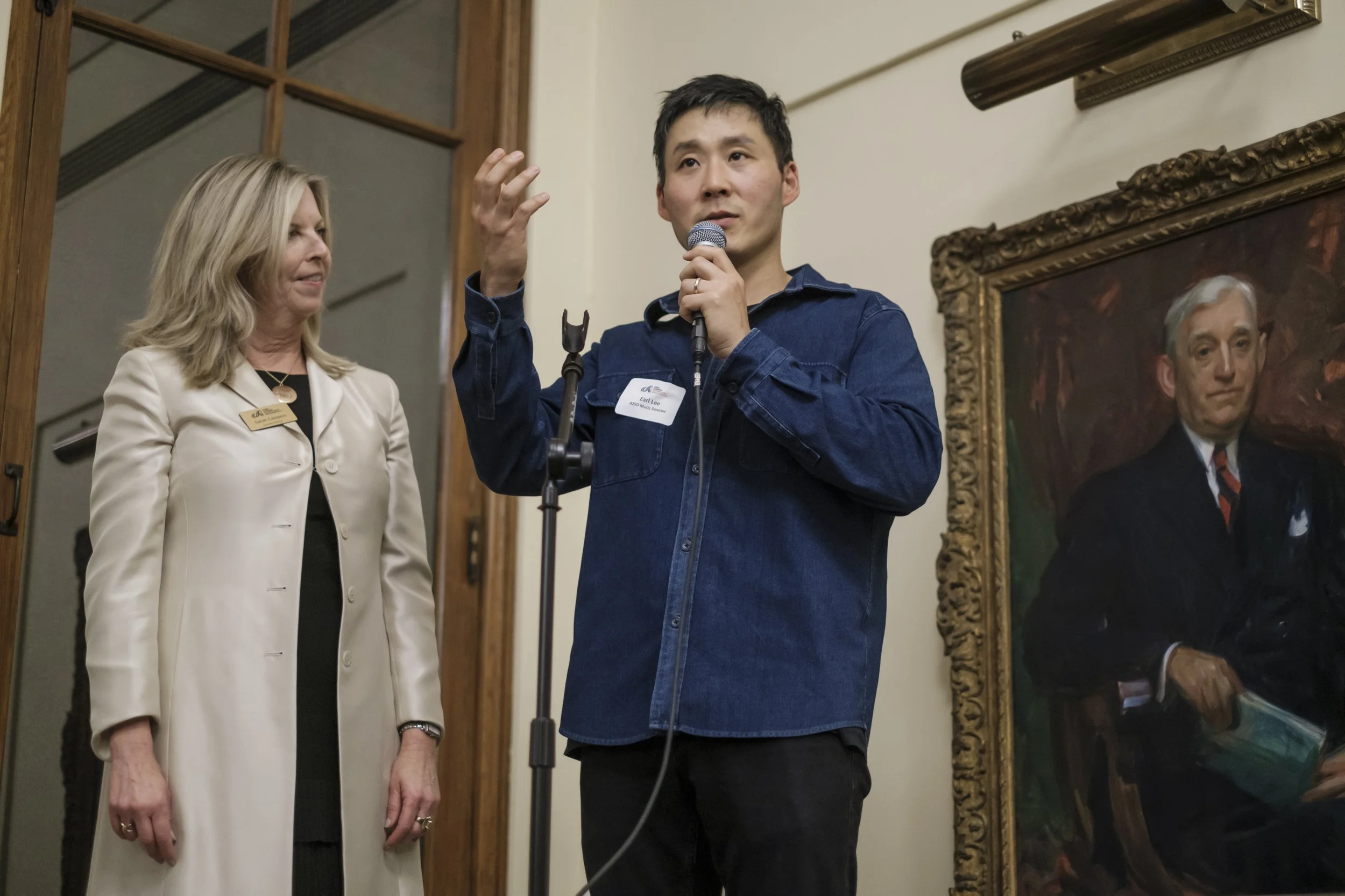 Conductor Earl Lee holding a microphone.