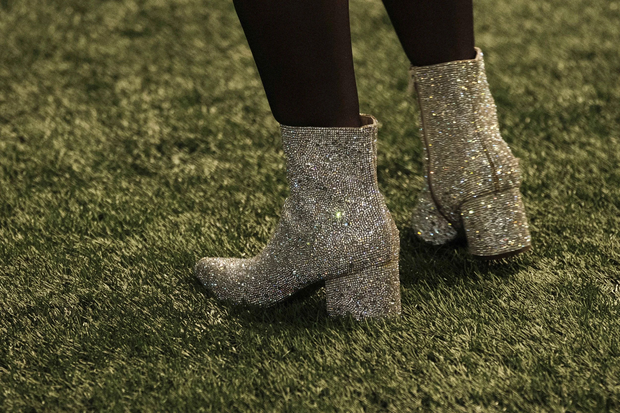 Sparkling shoes on the turf of a football field.