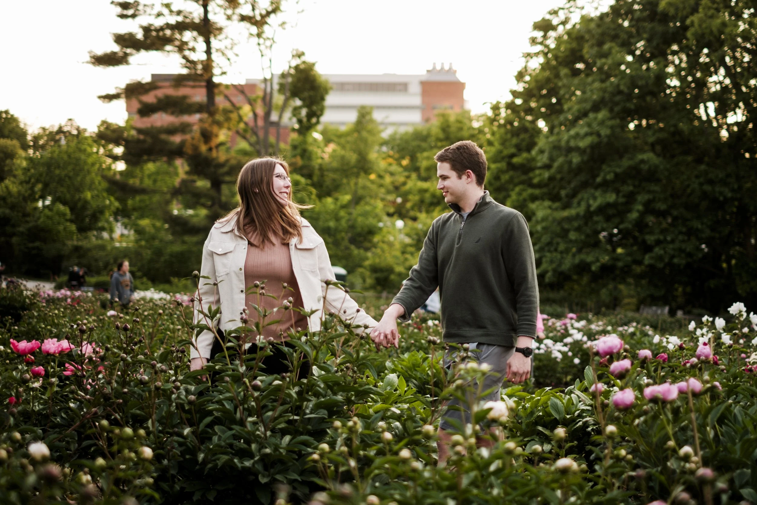 Couple walking hand-in-hand through Nichols Arboretum during engagement shoot