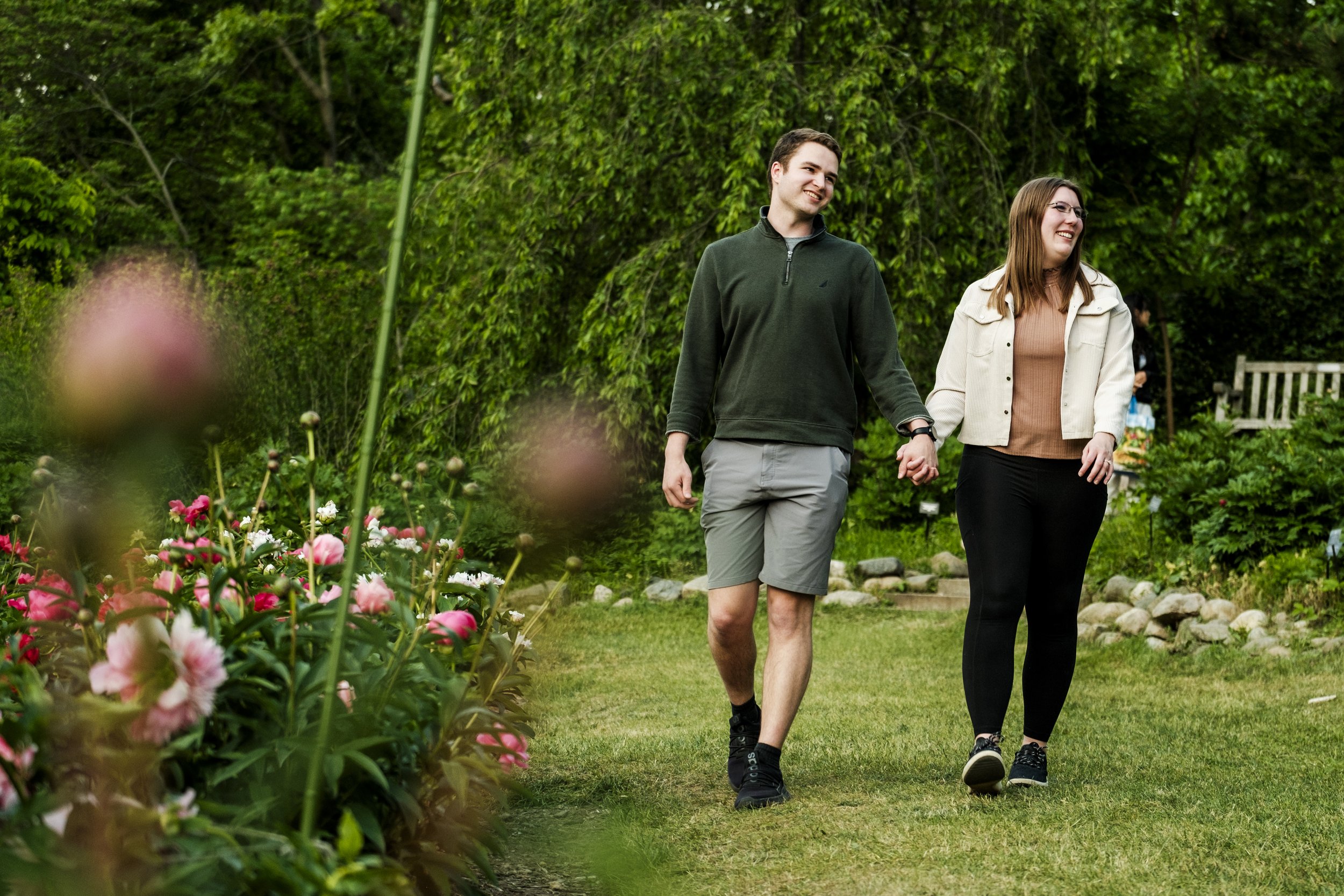 Couple walking hand-in-hand through Nichols Arboretum during engagement shoot