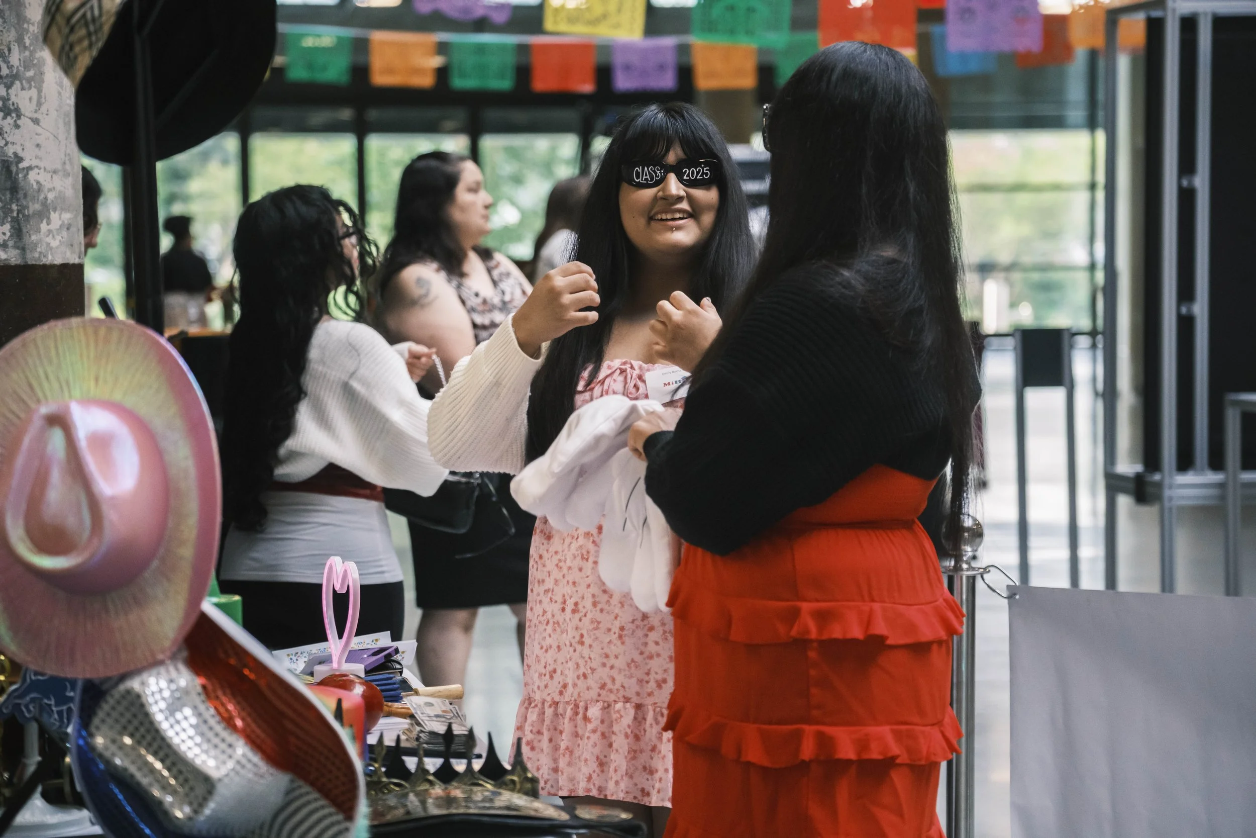 A person wears sunglasses that say "class of 2025" and smiles.