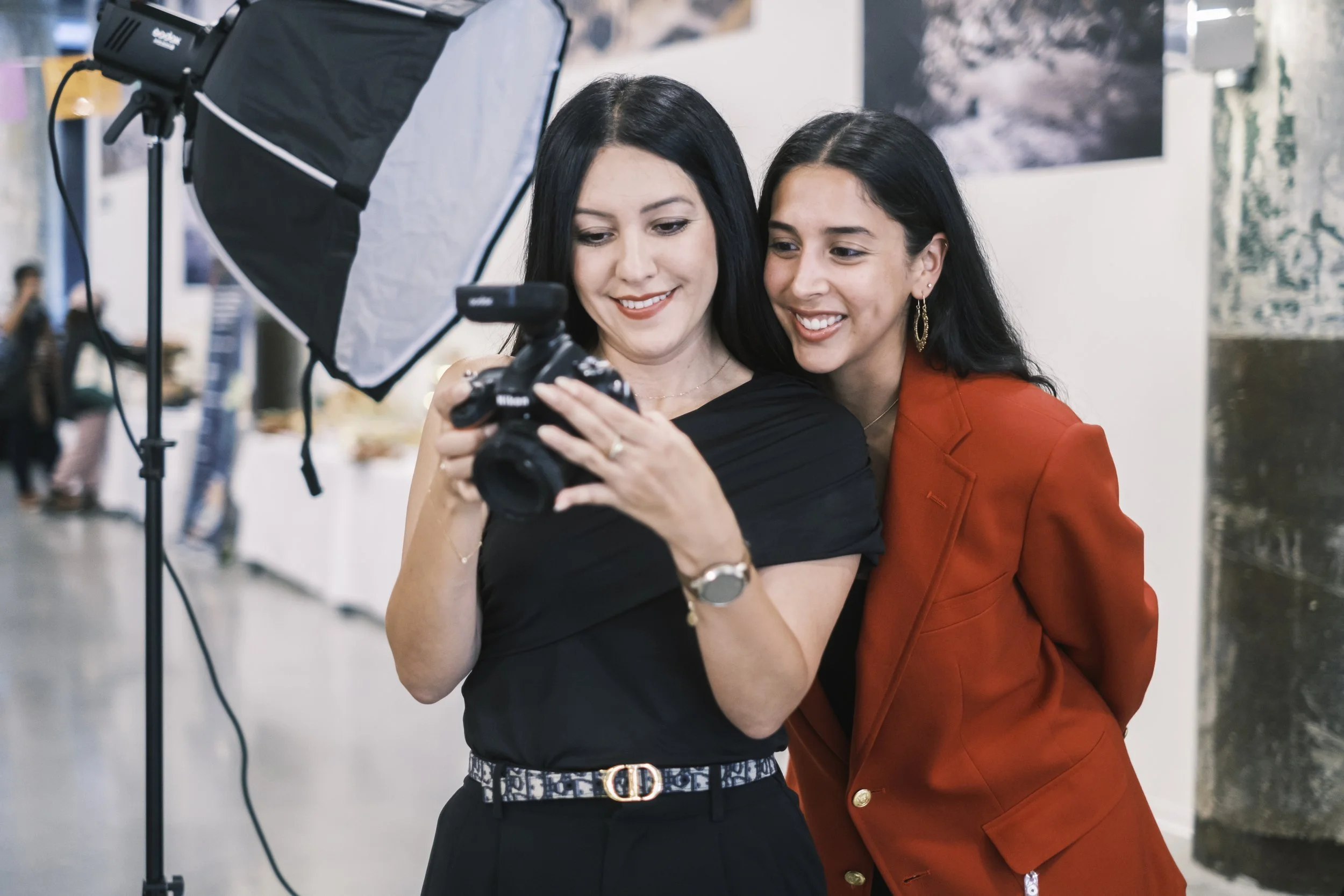 A headshot photographer showing a person a photo on the back of the camera at Michigan Hispanic Collaborative’s Gran Fiesta.
