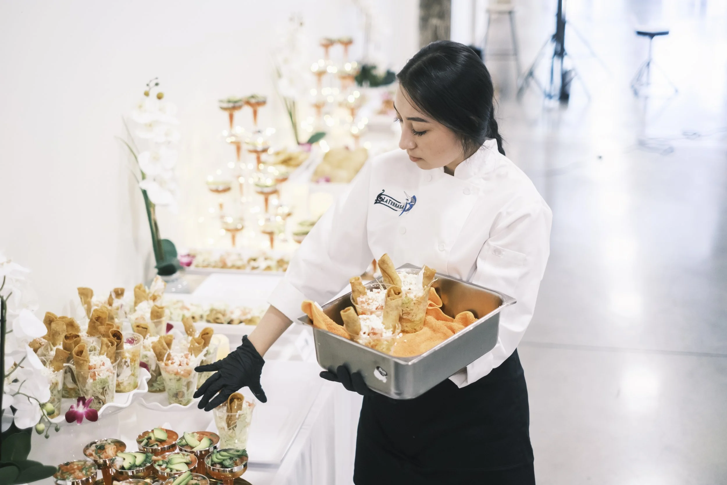 A caterer sets food on a table from La Terraza.