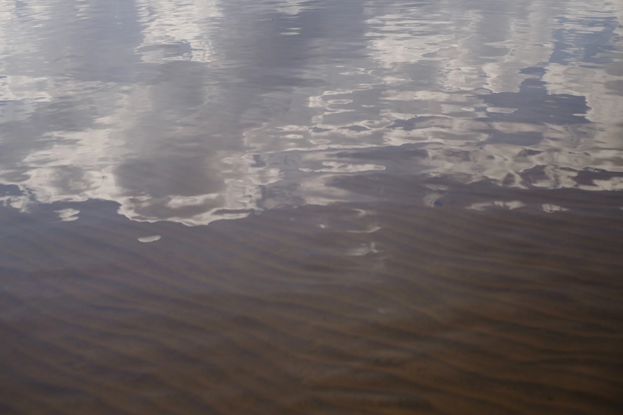 Clouds reflected in tannin-stained water at Grand Sable Lake, in the Upper Peninsula of Michigan