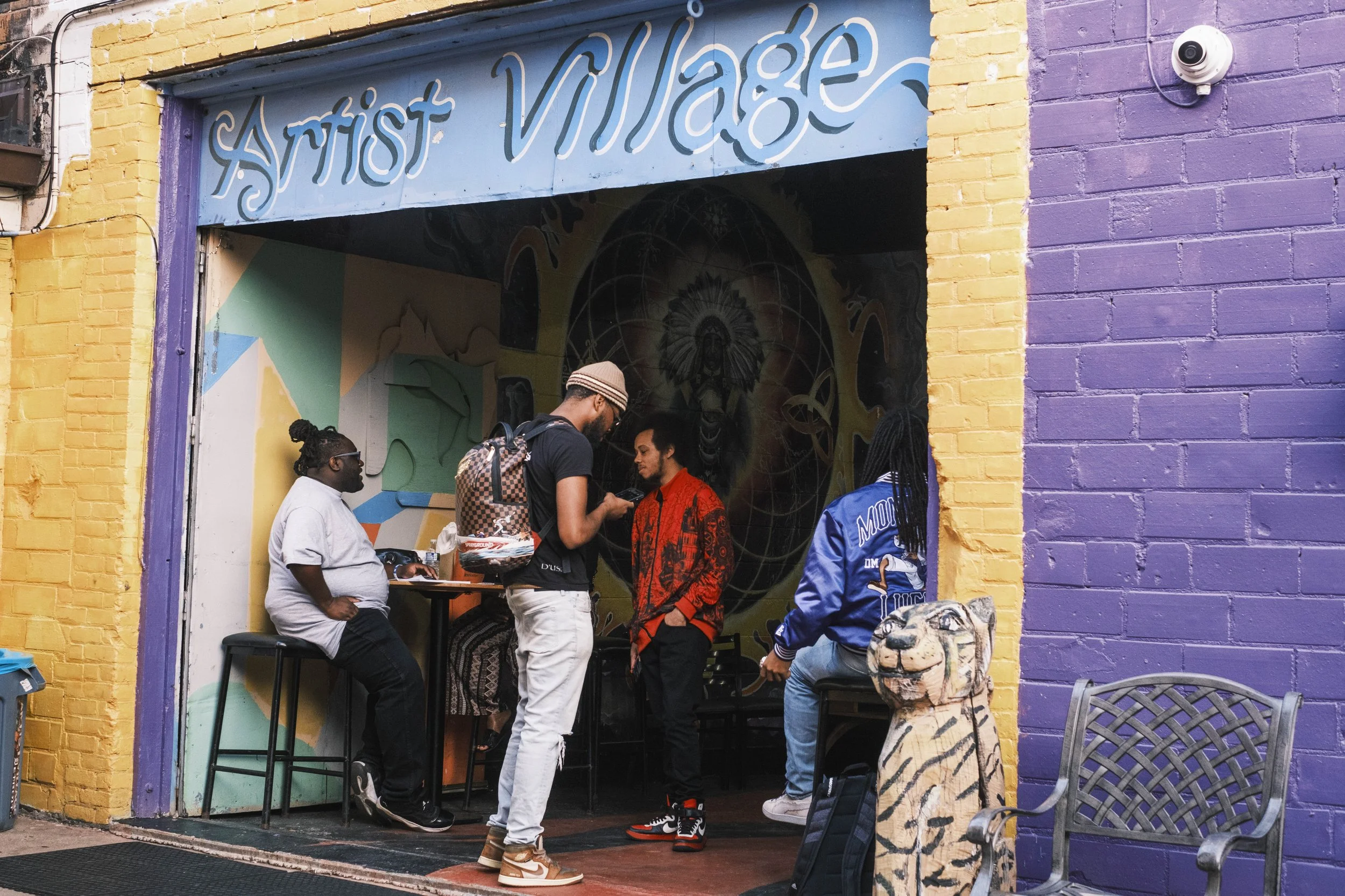 A group of artists stand near the entrance of Artist Village in Detroit